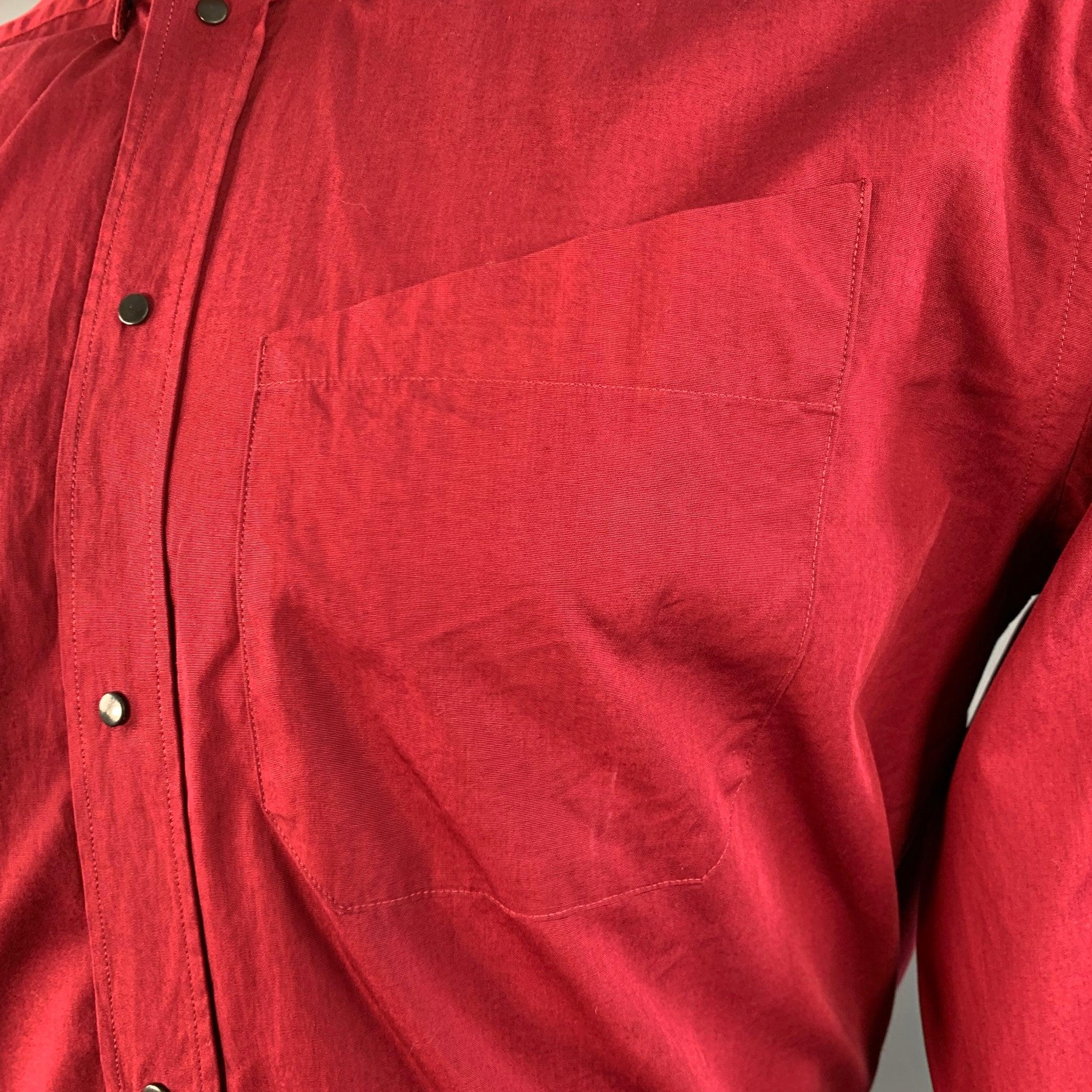 Camicia a maniche lunghe Thierry Mugler
in tessuto di cotone rosso con colletto a scatto, una tasca e chiusura a scatto. Made in France.Ottime condizioni di usato. Piccolo segno sul polsino. 

Contrassegnato:   39/15.5 

Misure: 
 
Spalla: 19,25