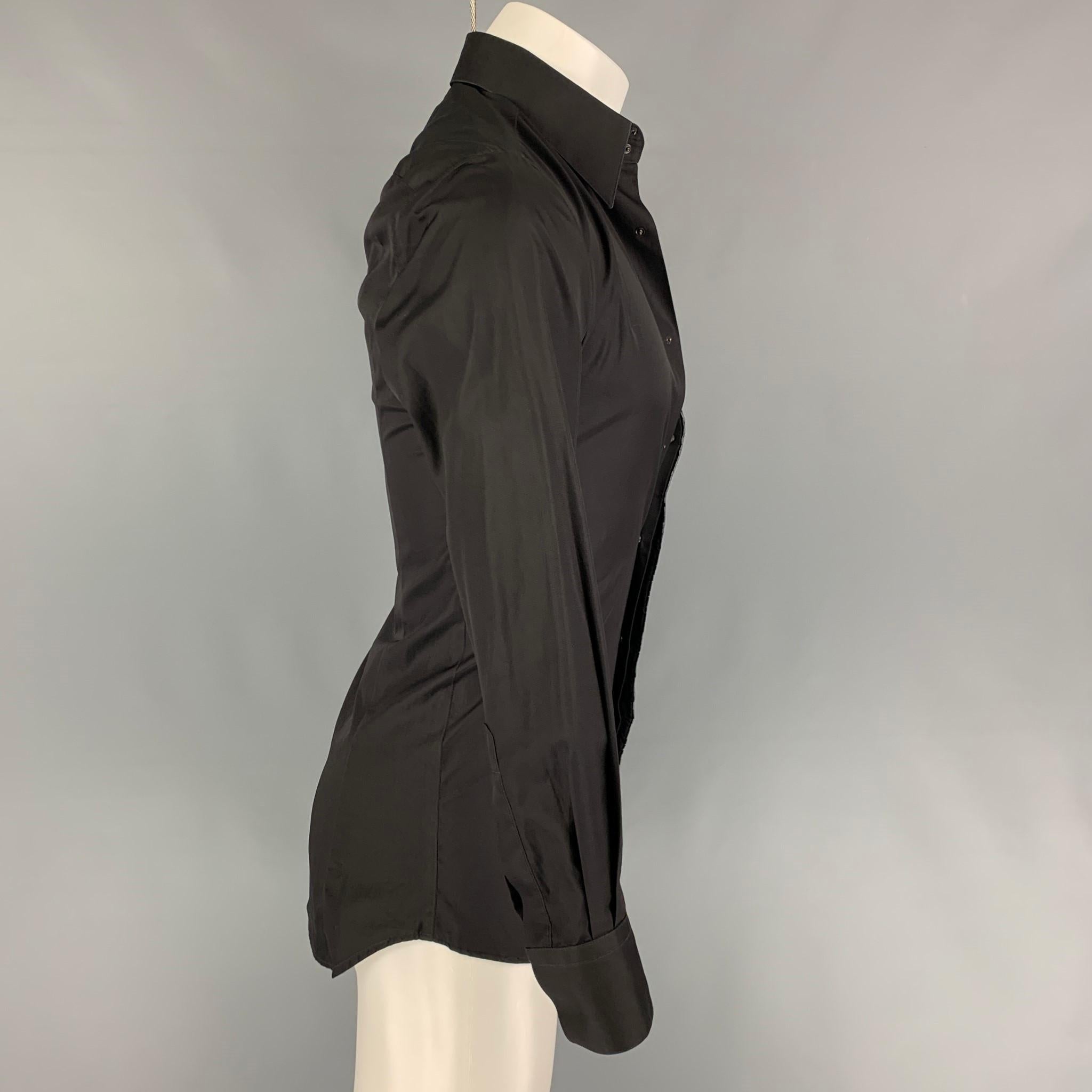 THIERRY MUGLER long sleeve shirt comes in a black cotton featuring a beaded trim, spread collar, and a hidden placket closure. Made in France. Shirt styled with a half button look but can be buttoned all the way.

Very Good Pre-Owned