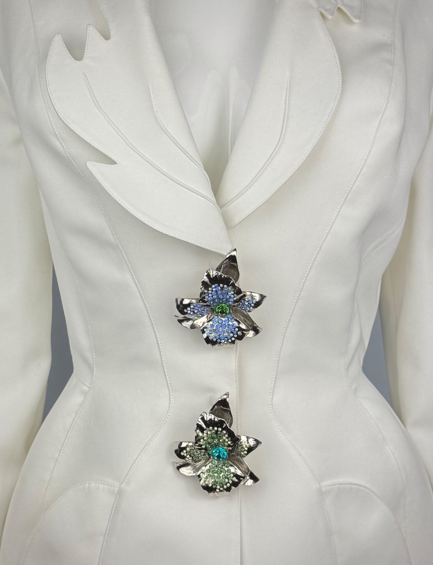 Gorgeous White Thierry Mugler Jacket from Spring/Summer 1995 Raffia Collection. 
Adorned with spectacular rhinestones encrusted metal flower brooches. 
Impeccable cut with wide shoulders, narrow waist, two front pockets and the most beautiful lapel!