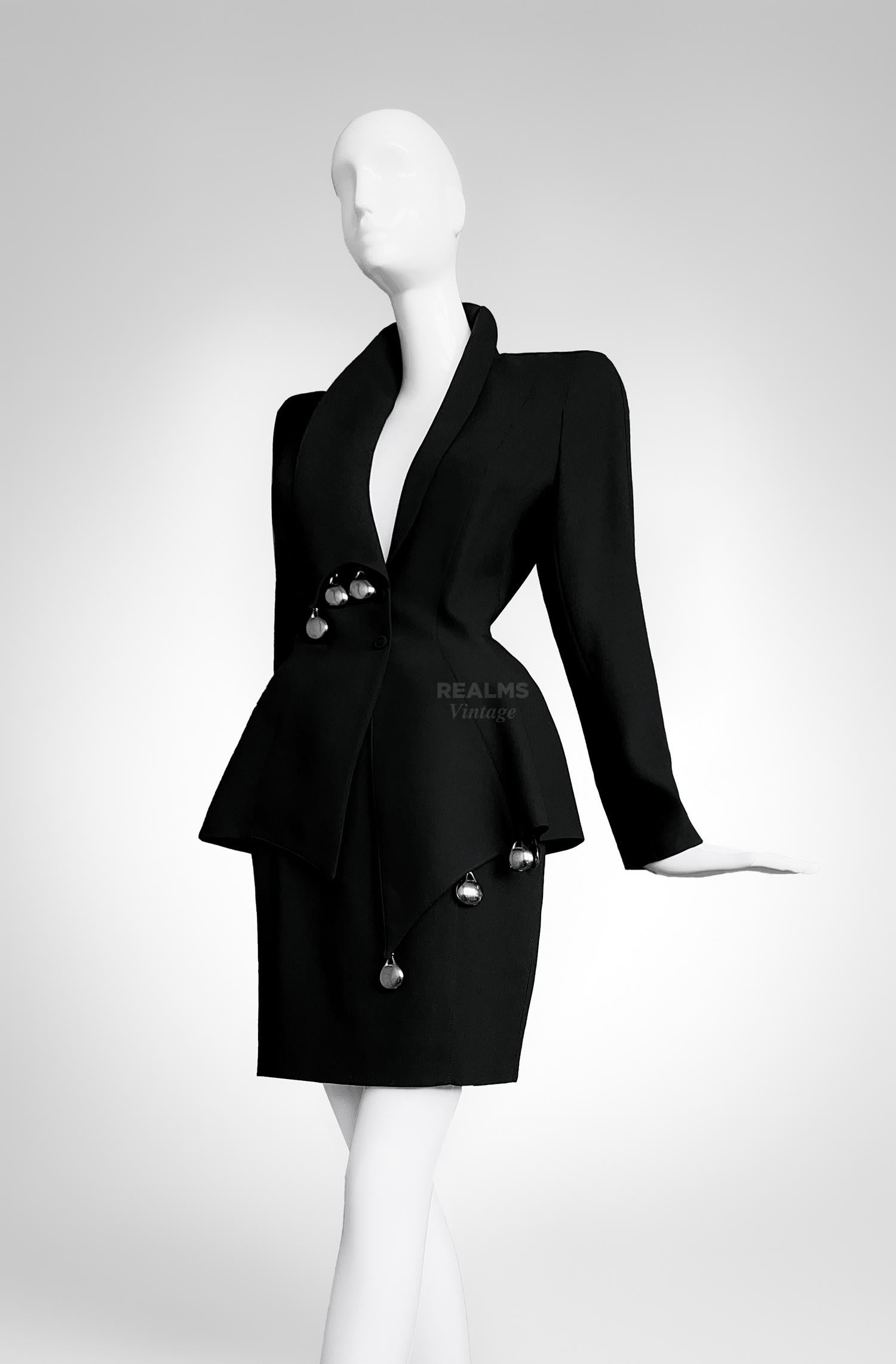 Thierry Mugler black skirt suit Spring Summer 1989 Collection.
Fabulous extremely rare Collector's Piece.

Dramatic black two piece ensemble (jacket and skirt).  
Masterful construction, a fabulous Thierry Mugler creation. 
Extraordinairy shape!