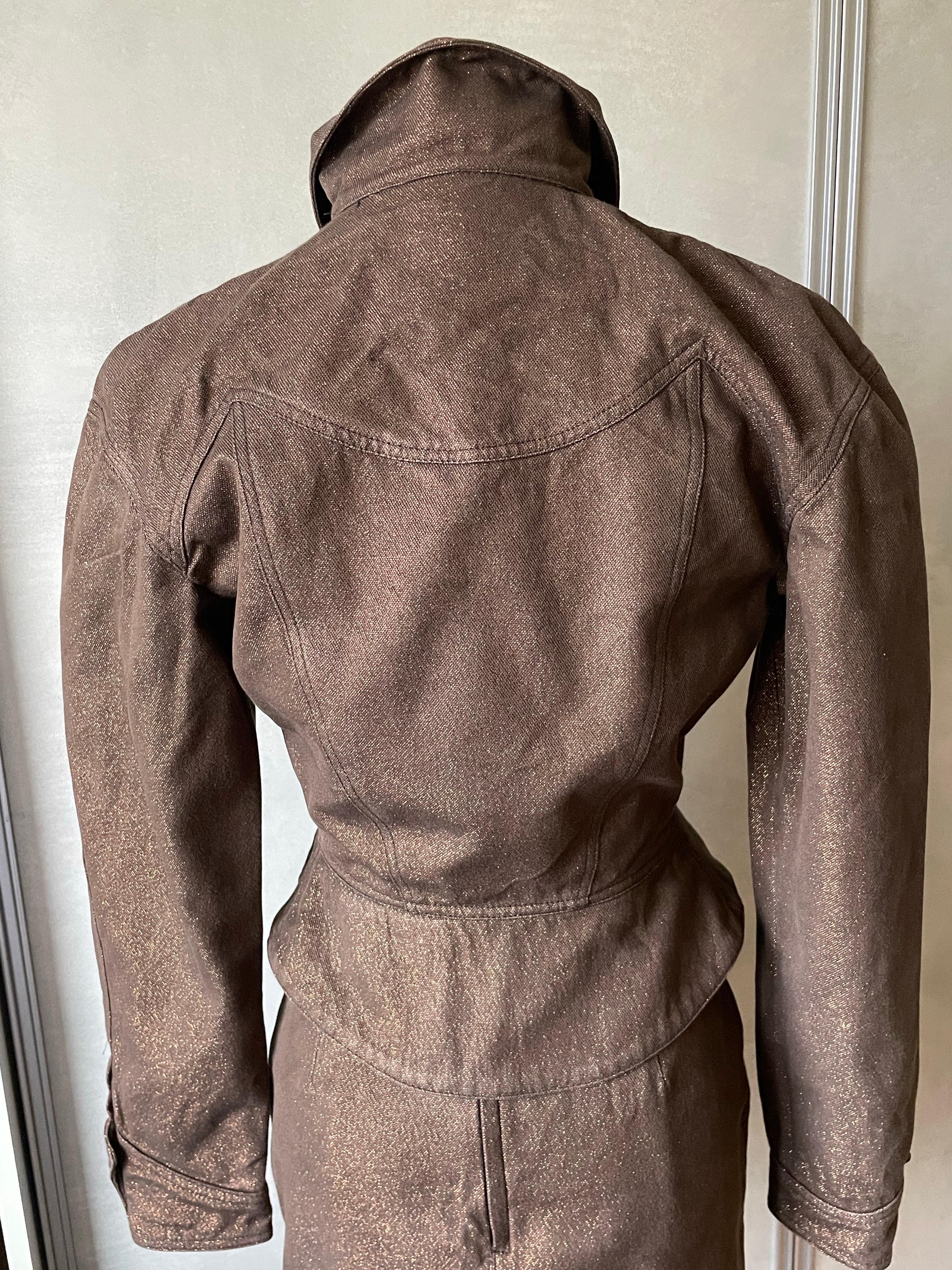 Thierry Mugler. Magnifique costume marron avec lurex, effet pailleté doré, coupe ajustée qui met en valeur la taille. Très original. Combien pour une taille 38 ? S'adapte très bien. L'ensemble est en très bon état, juste une couture qui s'est