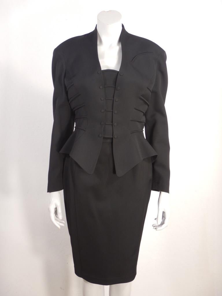 Tailleur vintage anni '90 di Thierry Mugler in lana pettinata nera con giacca peplo e gonna a matita. La giacca presenta spesse 