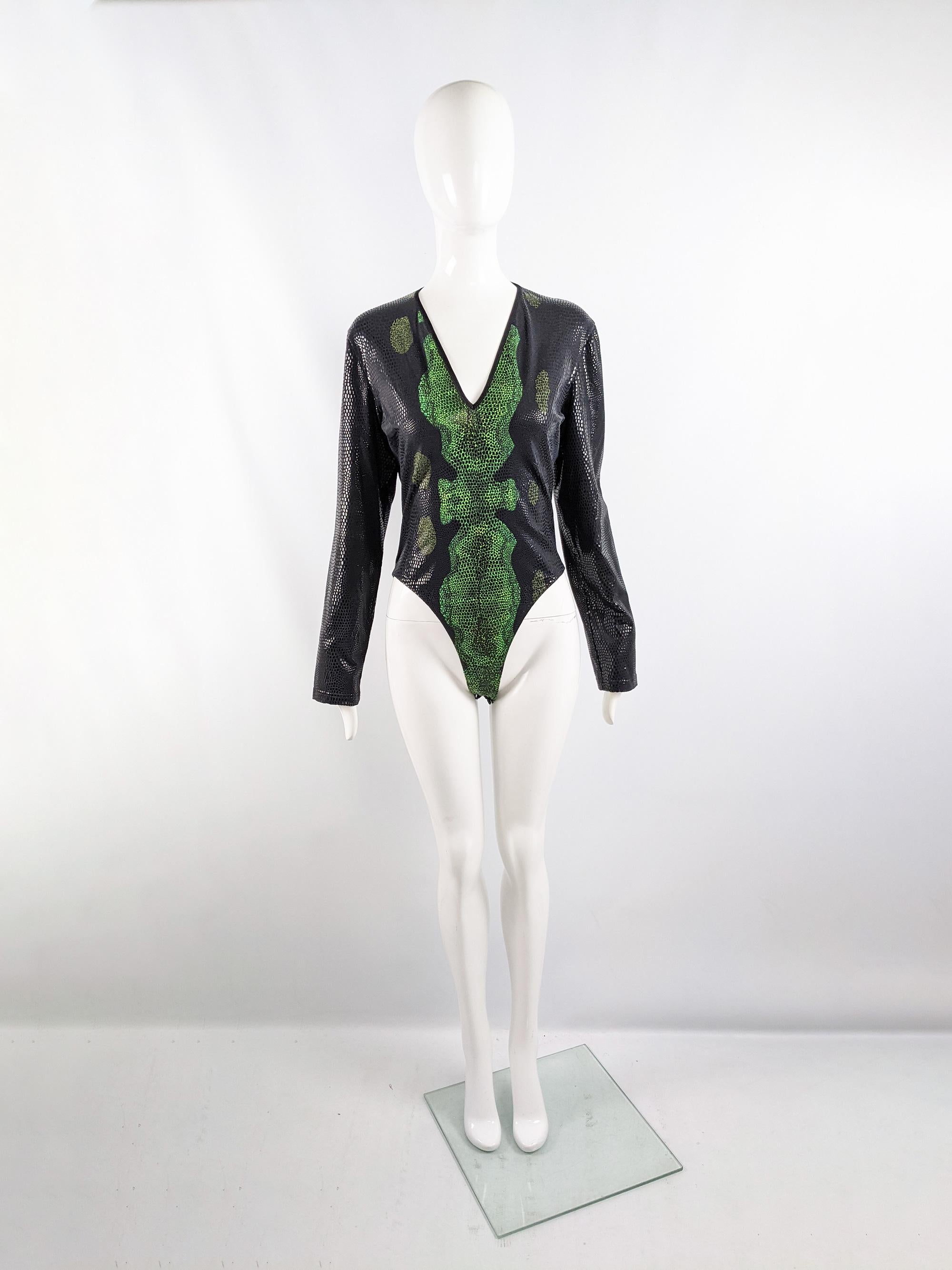 An amazing vintage Thierry Mugler bodysuit from c. the late 90s. In a black and green snakeskin print fabric with rubber details creating a scale effect throughout. It has long sleeves and a deep v neckline, perfect for a party. 

Size: Marked