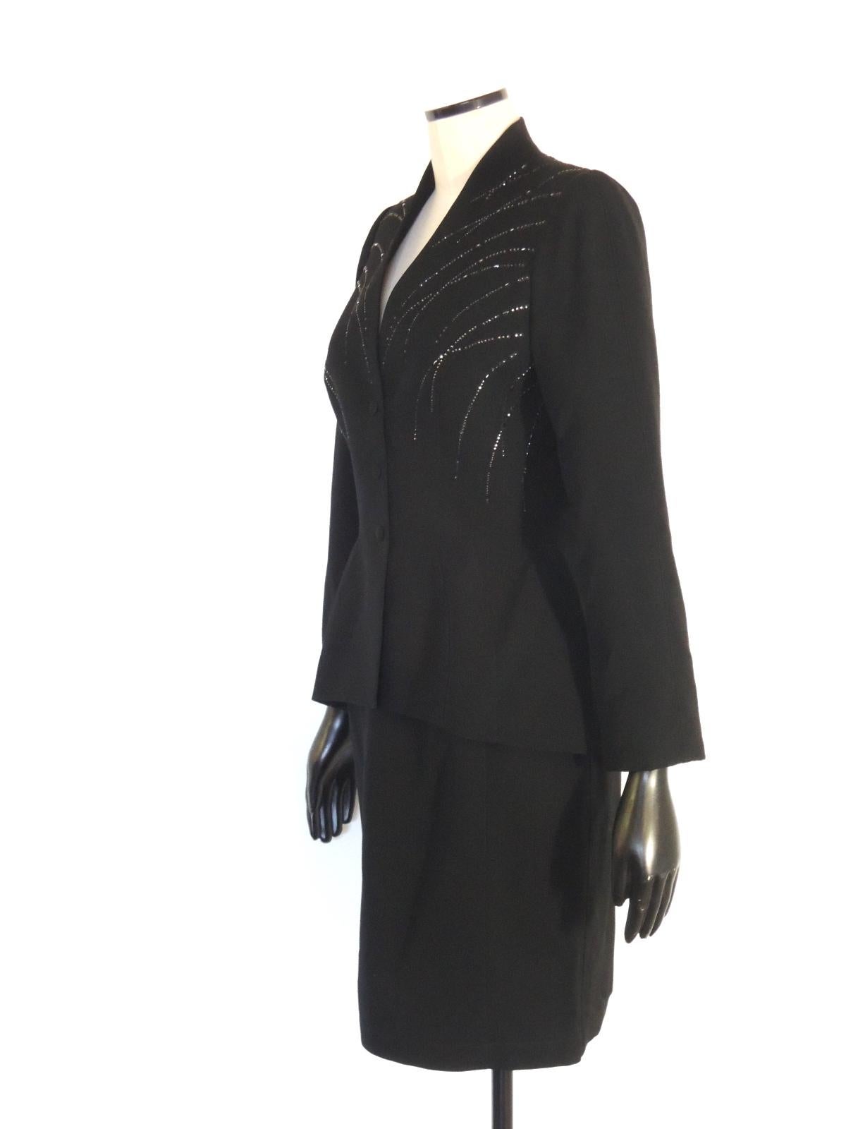 Vintage Thierry Mugler black wool 2-piece skirt suit with reflective embellishments on the jacket. 3-snap front closure on the jacket, back zipper and hook closure on the skirt. I note a 