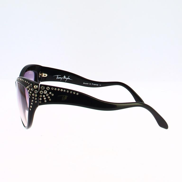 Squisiti occhiali vintage degli anni '90, disegnati dall'iconico couturier francese Thierry Mugler.
Questa rara montatura cat-eye incarna l'audace eleganza e l'estetica futuristica che definivano lo stile di Mugler in quell'epoca.
La struttura è