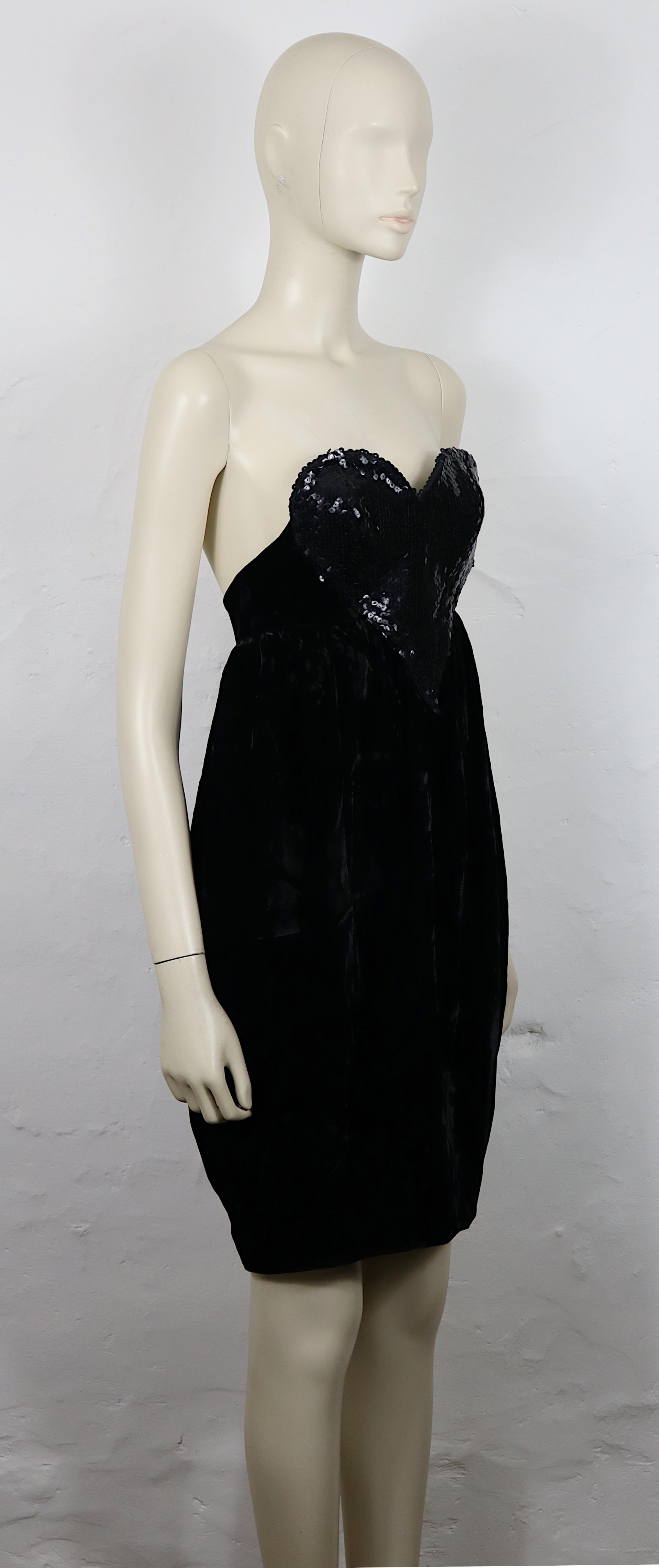 THIERRY MUGLER Vintage-Kleid aus schwarzem Samt, trägerlos und mit einem wunderschönen Herz-Bustier aus Pailletten.

Dieses Kleid hat folgende Eigenschaften:
- Schwarzer Pannesamt.
- Schwarzes herzförmiges Pailletten-Bustier.
- Trägerlos.
-