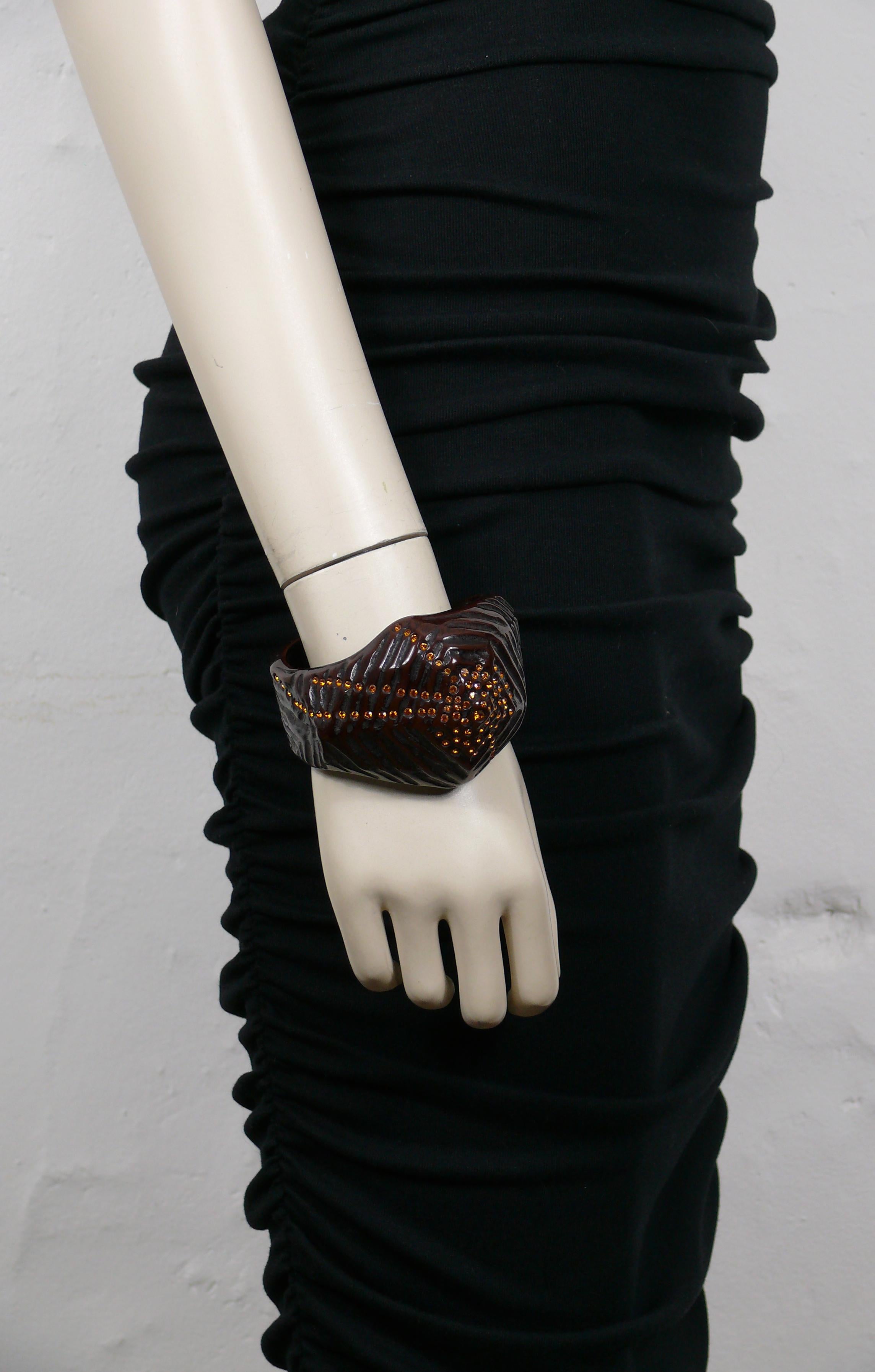 THIERRY MUGLER vintage rare textured brown resin asymetric cuff bracelet embellished with orange colour crystals.

Embossed TM.

Comes from a French private THIERRY MUGLER jewelry collection.

Indicative measurements : inner circumference approx.