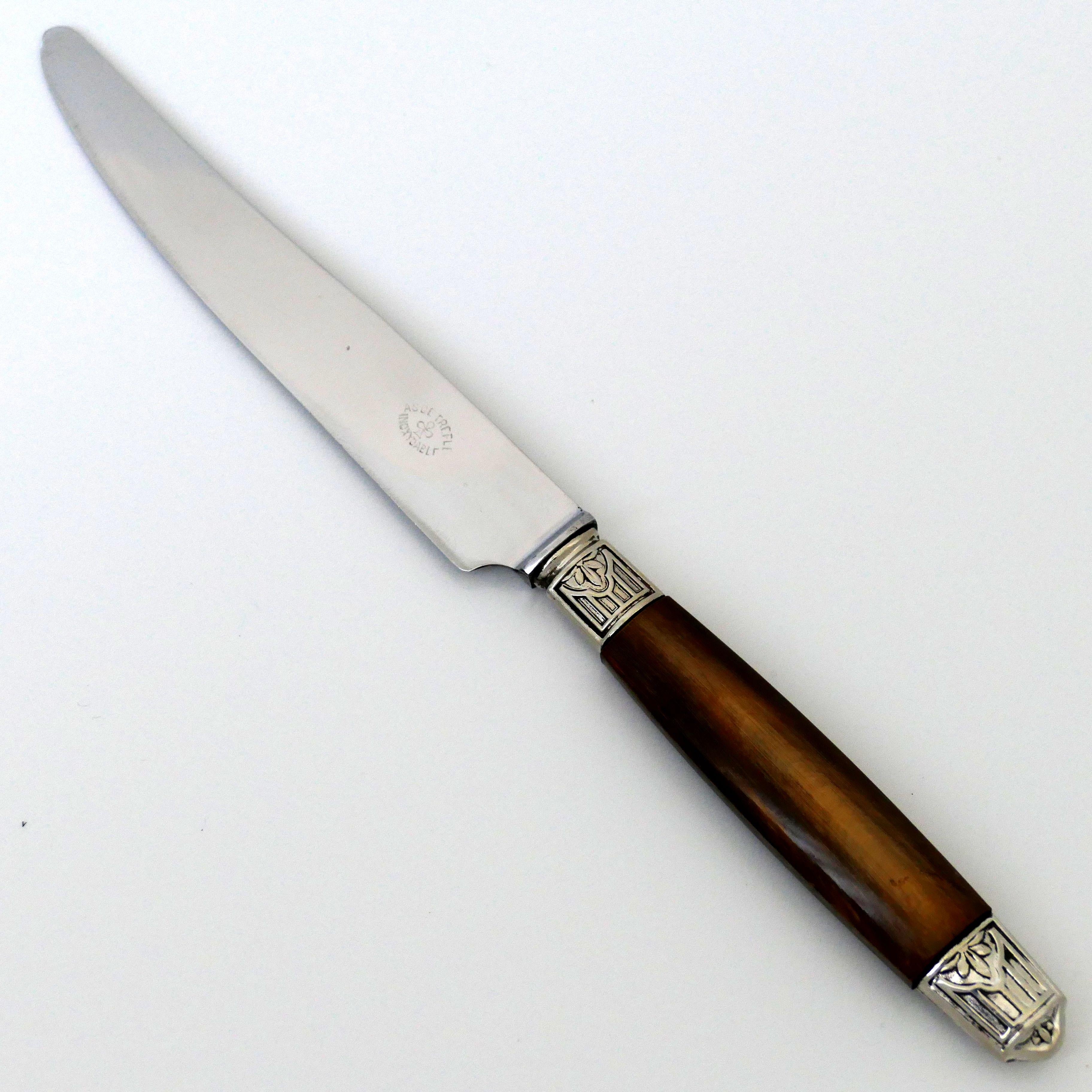 This service includes twelve dinner knives with Art Deco decoration. Horn handles, silver ferrules and collars. The stainless steel blades bear the mark 