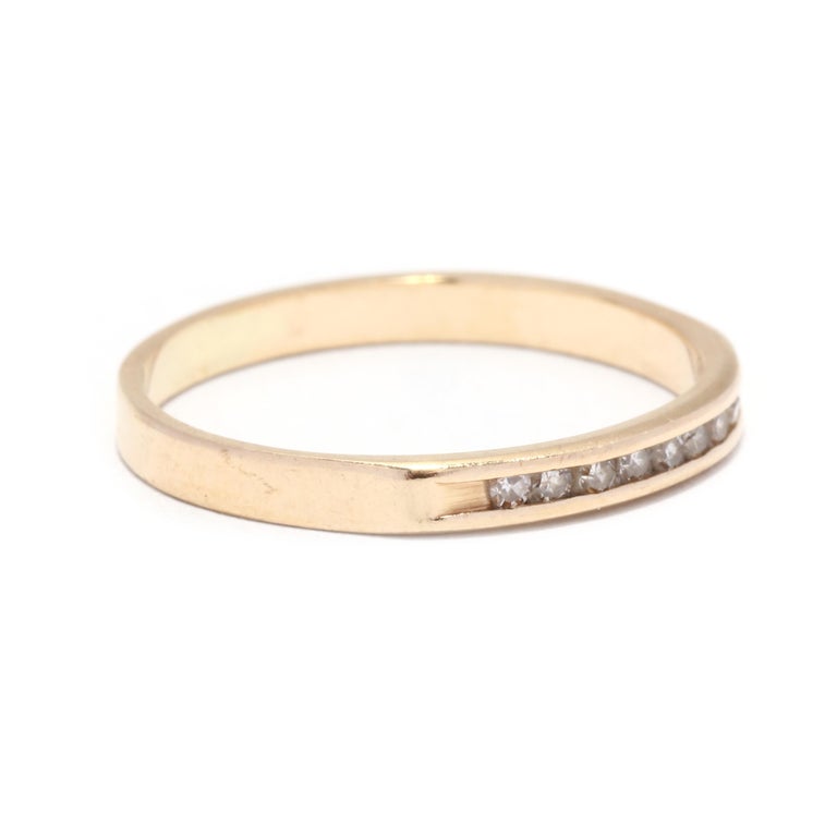 A vintage 14 karat yellow gold thin diamond band. This stackable ring features nine channel set single cut round diamonds weighing approximately .08 total carats and with a straight band.

Stones:
- diamonds, 9 stones
- single cut round
- 1.2 mm
-