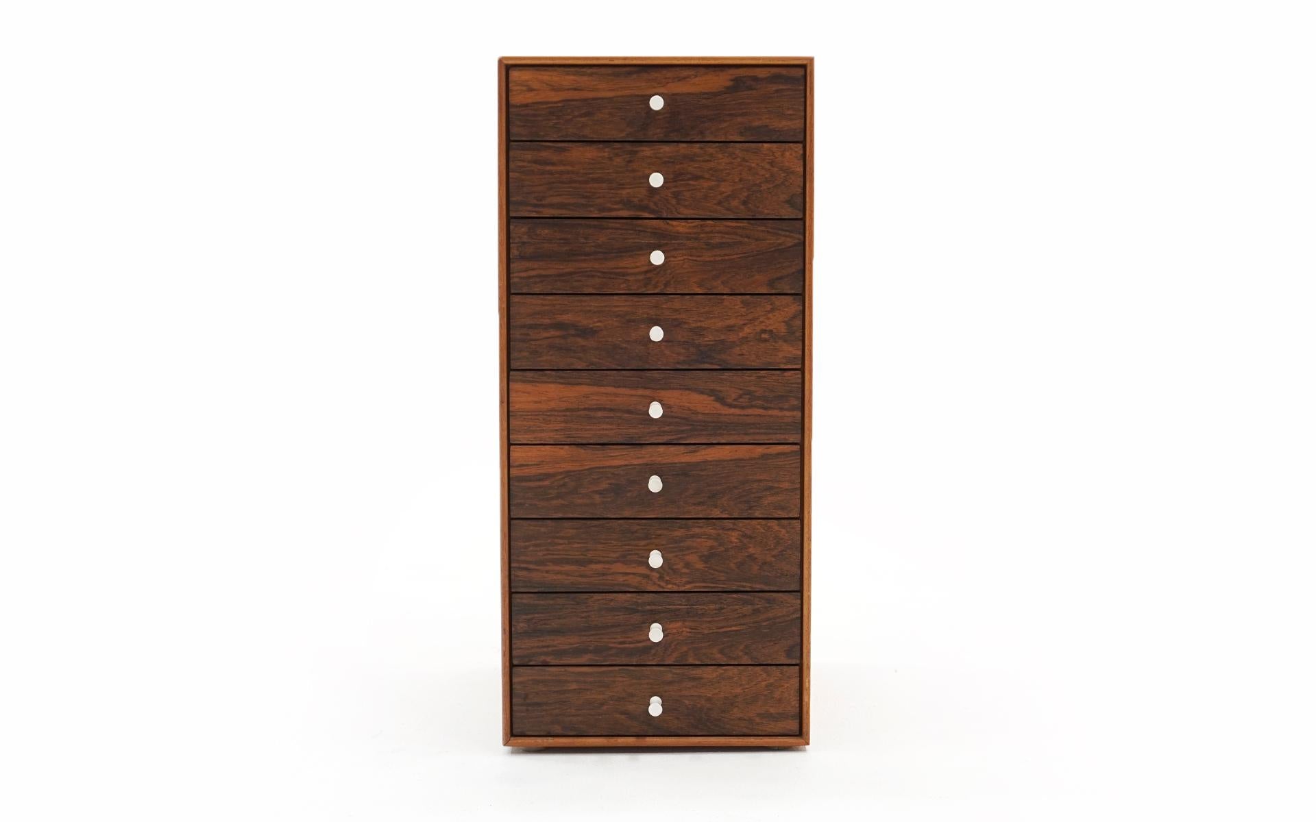 Rare early George Nelson for Herman Miller nine drawer jewelry / miniature cabinet in rosewood and teak with porcelain pulls. Completely original, never refinished very good condition. Signed with the early white round medallion.