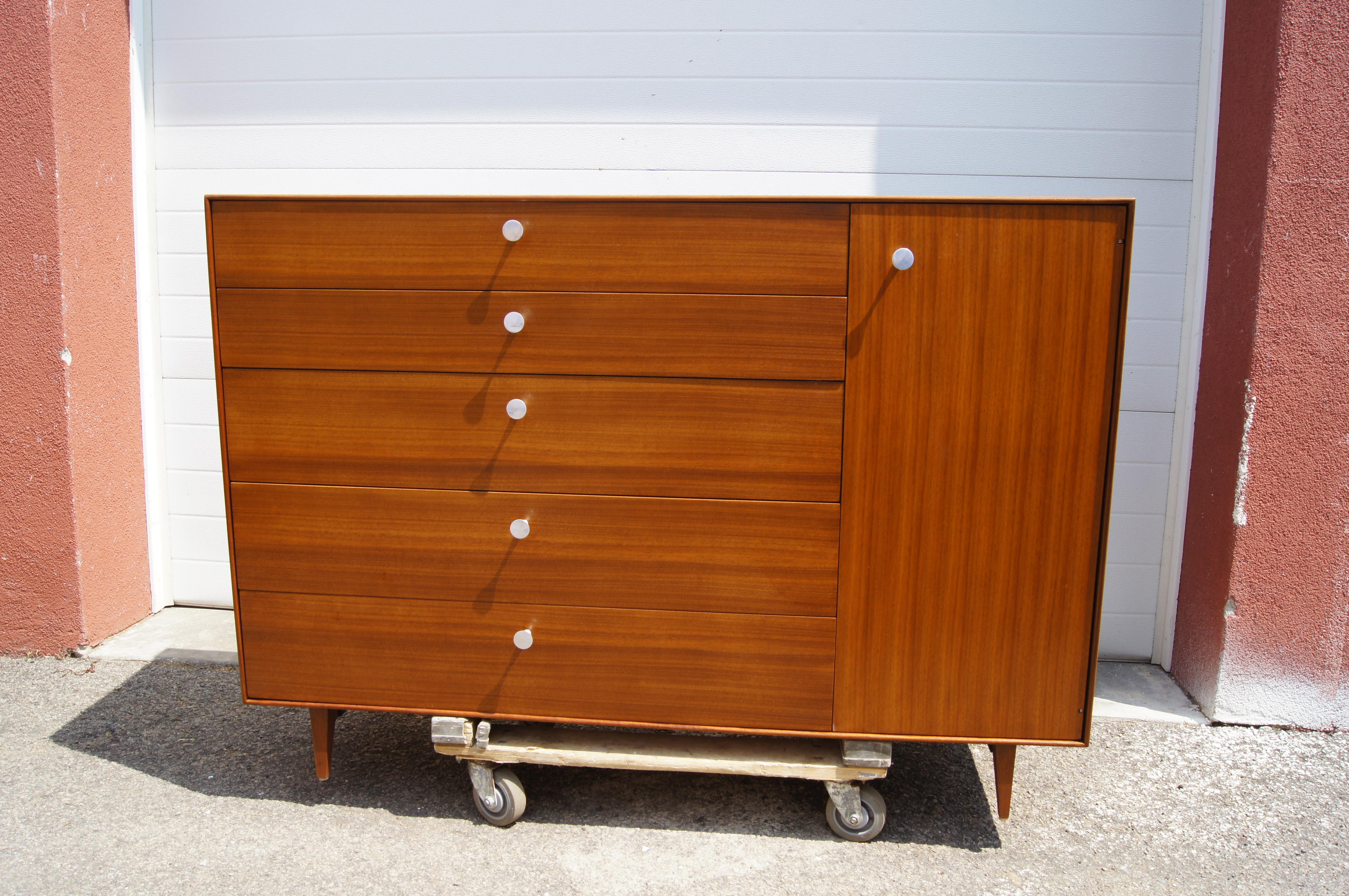 This gorgeous dresser is part of George Nelson's 1950s Thin Edge collection for Herman Miller, which takes its name from the elegant, slim profile. Tapered trestle legs elevate the walnut case, with five graduated drawers, the topmost of which is
