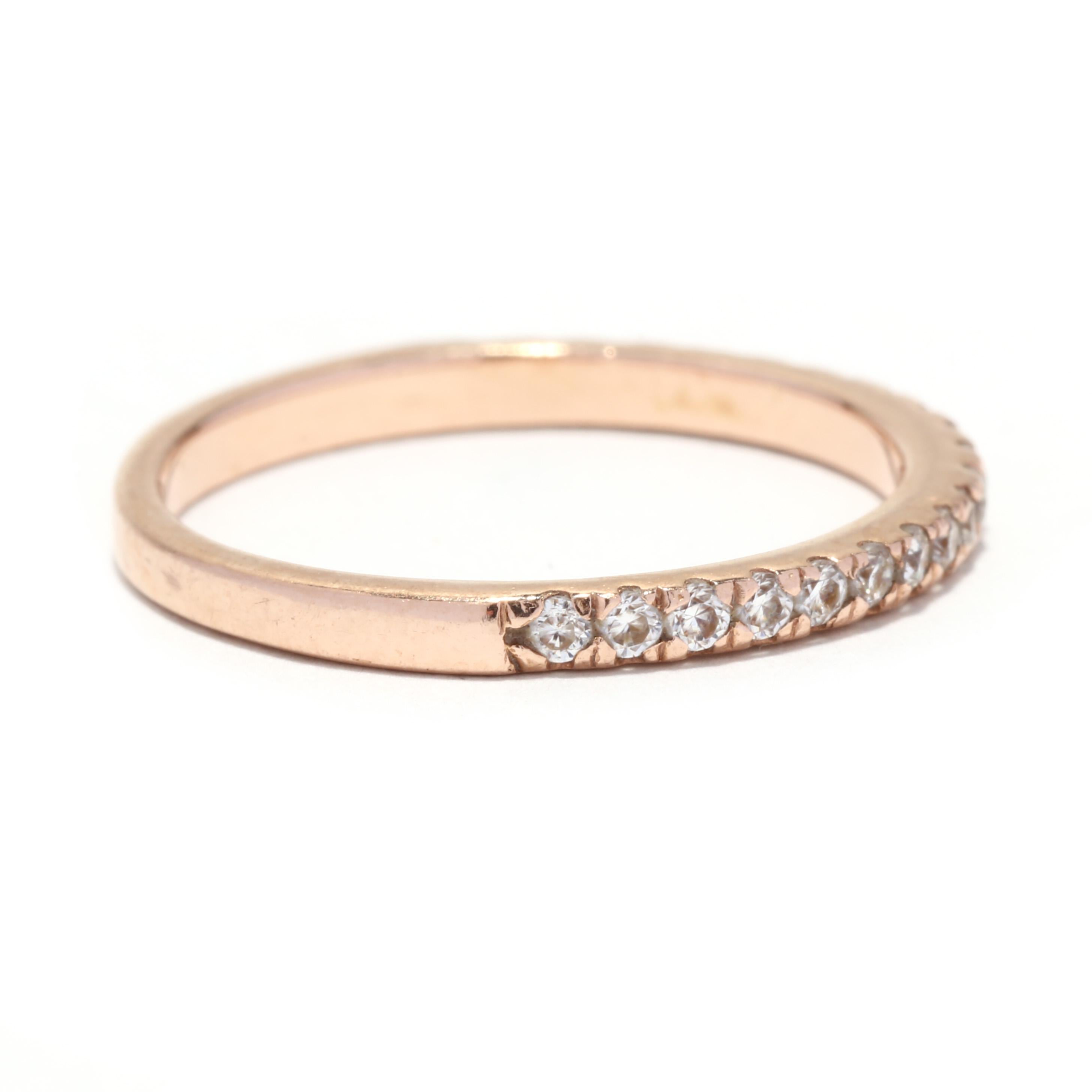 A 14 karat rose gold thin moissanite wedding band. This stackable band features pavé set, round brilliant cut moissanites weighing approximately .30 total carats and with a thin band.

Stones:
- moissanites, 21 stones
- round brilliant cut
- 1.5