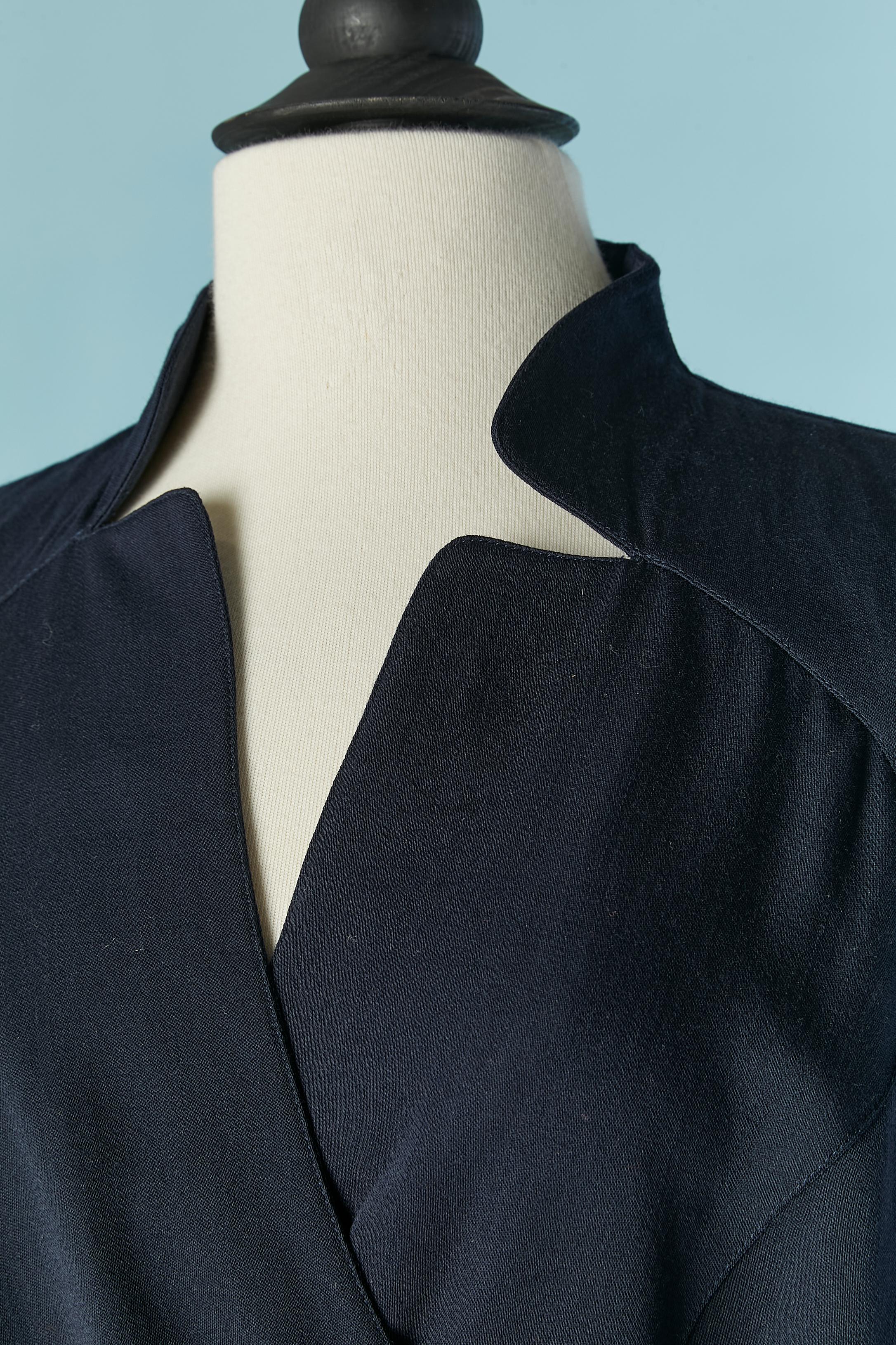 Thin navy blue wool wrap dress . The fabric composition tag has been cut. There is lining only inside the bottom back of the dress and the composition is probably acetate or rayon. 
Snap closure on the middle front ( and inside, to hold the wrap)