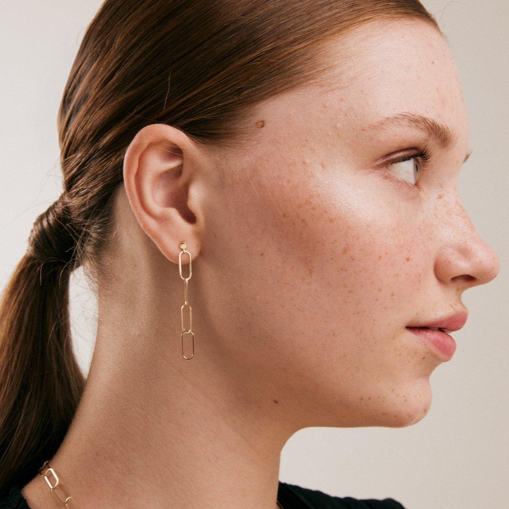 Introducing the 14K Solid Gold Dainty Paperclip Chain Drop Earrings from Orena Jewelry the embodiment of modern sophistication and artisanal craftsmanship. Each pair is meticulously fashioned by hand, offering a sleek and elegant statement for those