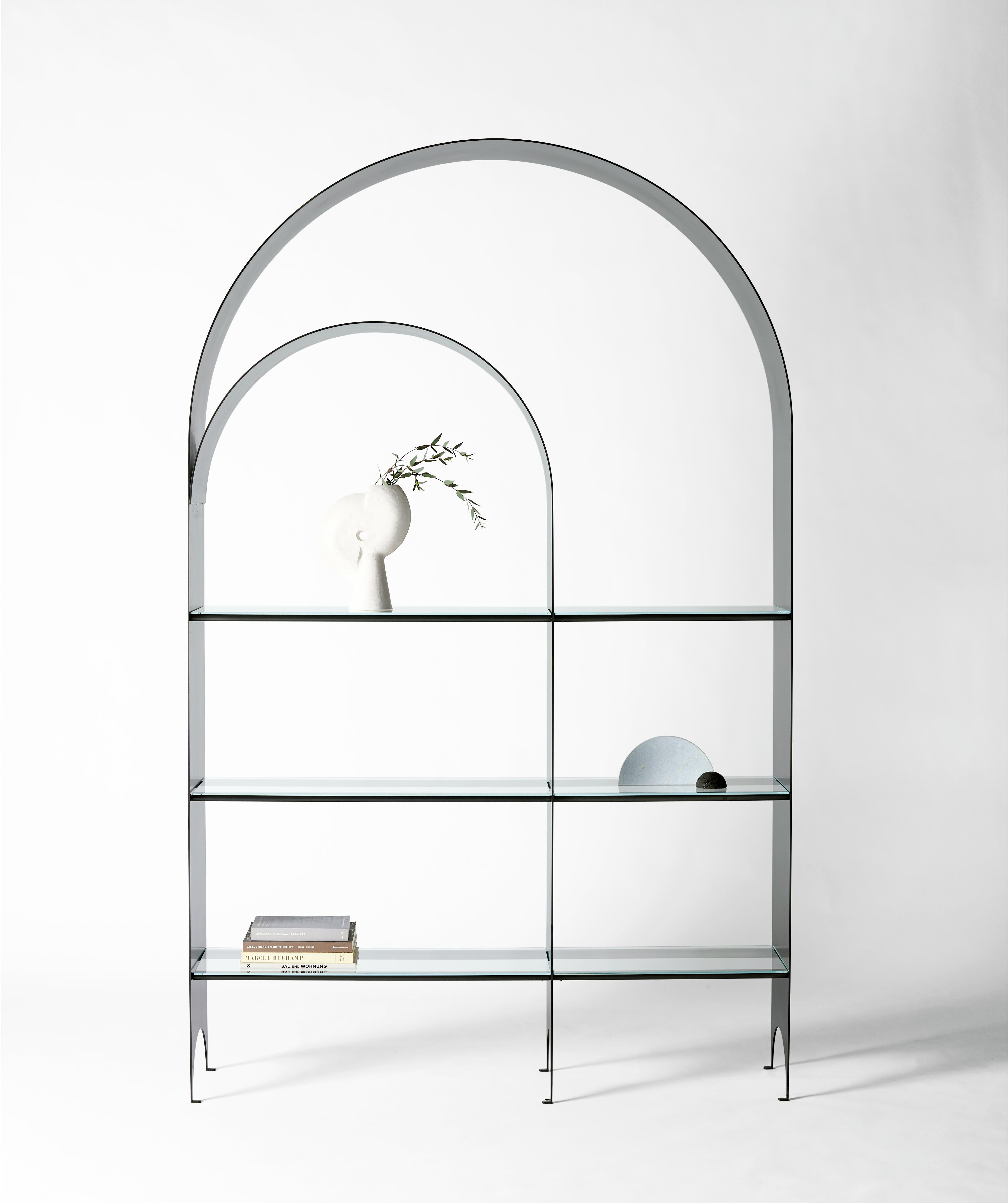 The thin shelf is the newest addition to the thin series, a collection exploring the potential of rigid yet pliant steel plates. The blackened steel arch of the Thin Shelf delicately extends upward from the floor tracing a double line along the