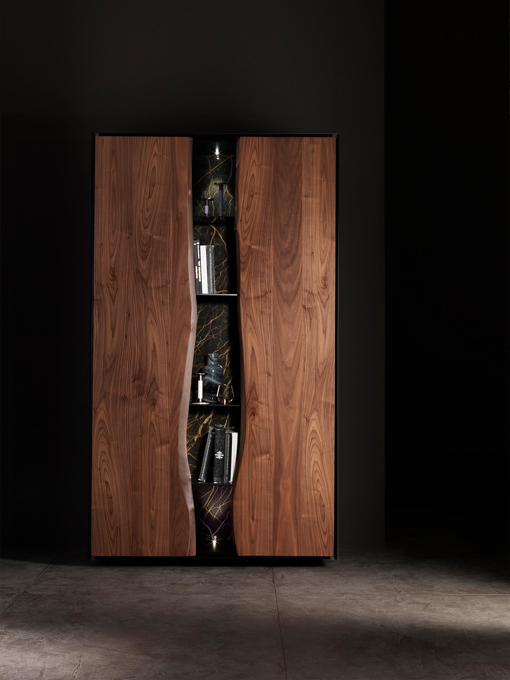 Think Twice Cabinet by Francesco Profili
Dimensions: W 135 x D 60 x H 235 cm 
Materials: Walnut, Noir Saint Laurent Marble, Glass Shelves, Matt Lacquered.

The detail-rich cabinet inherits the lines of the collection, developing them in the vertical