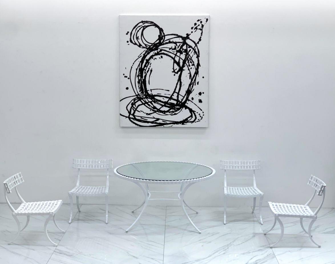 This set is really incredible-- a rare Thinline Klismos dining set. This gorgeous set in white powder coat features the notable klismos curvy legs on both the chairs as well as the dining table. Prized by designers, klismos dining chairs and accent