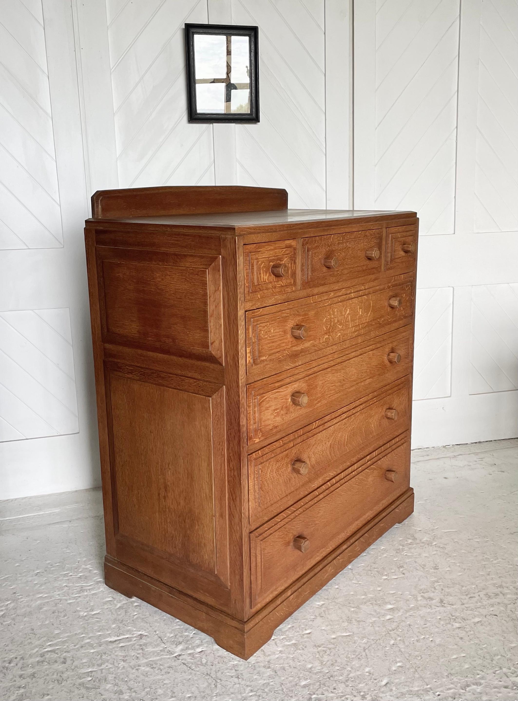 Thirties oak chest of drawers

Seven drawers with stepped drawer fronts and raised panelled sides

Stylised faceted octagonal handles and shaped back rail

Designed by Paul Matt

Brynmawr Furniture Makers Ltd

Circa 1930

Height 108cm.  Width 94cm.