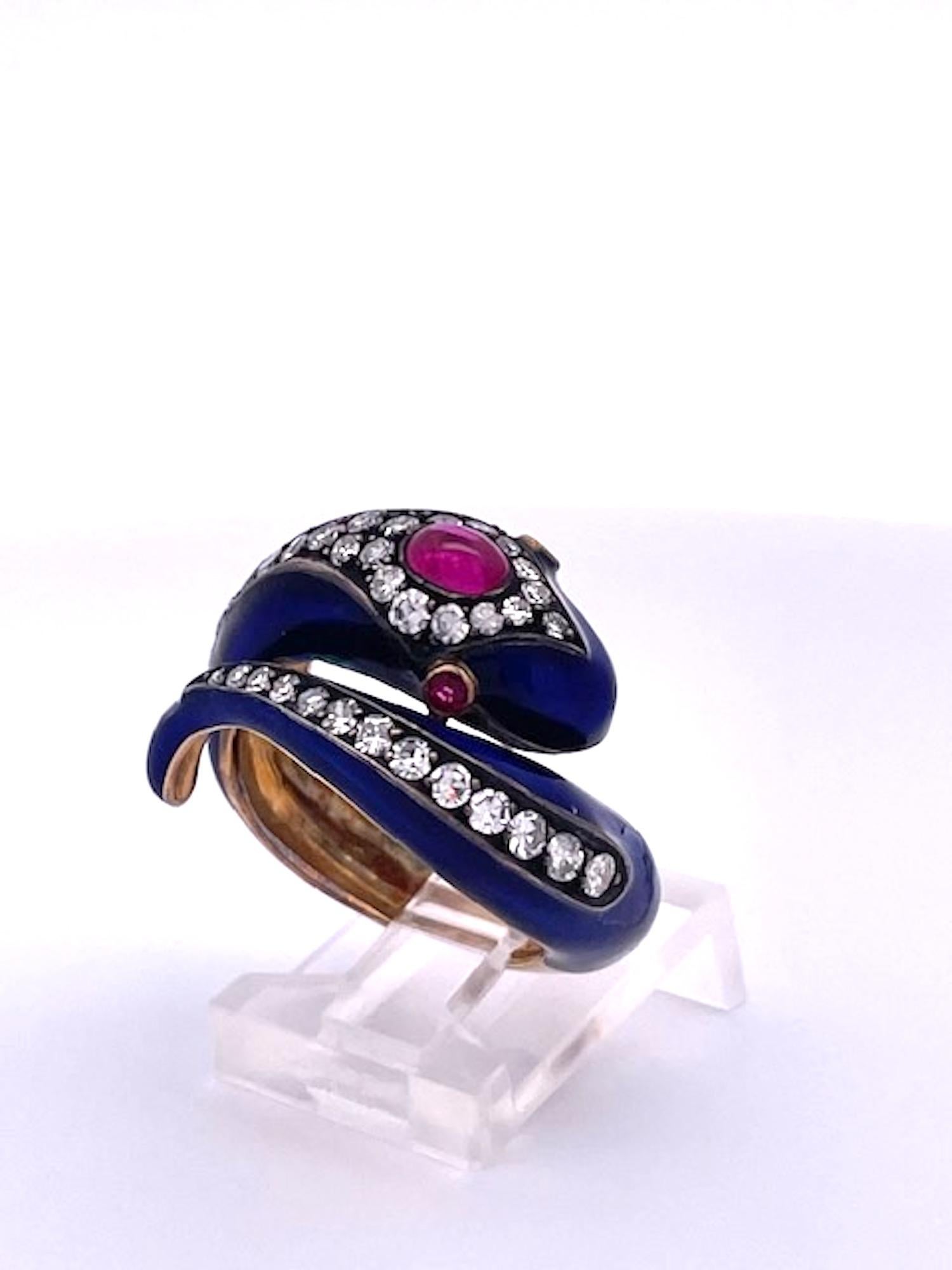 This 18K snake ring is enameled in Cobalt blue and has Rubies and Diamonds all around.  This ring is from the 1800's and is remarkable condition.The head is set with one (1) oval Ruby Cabochon of 0.36 carats and there are two Ruby eyes. In addition