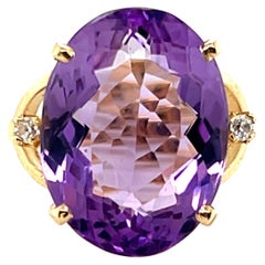 This contemporary 14 karat yellow gold ring features a striking oval-cut amethys