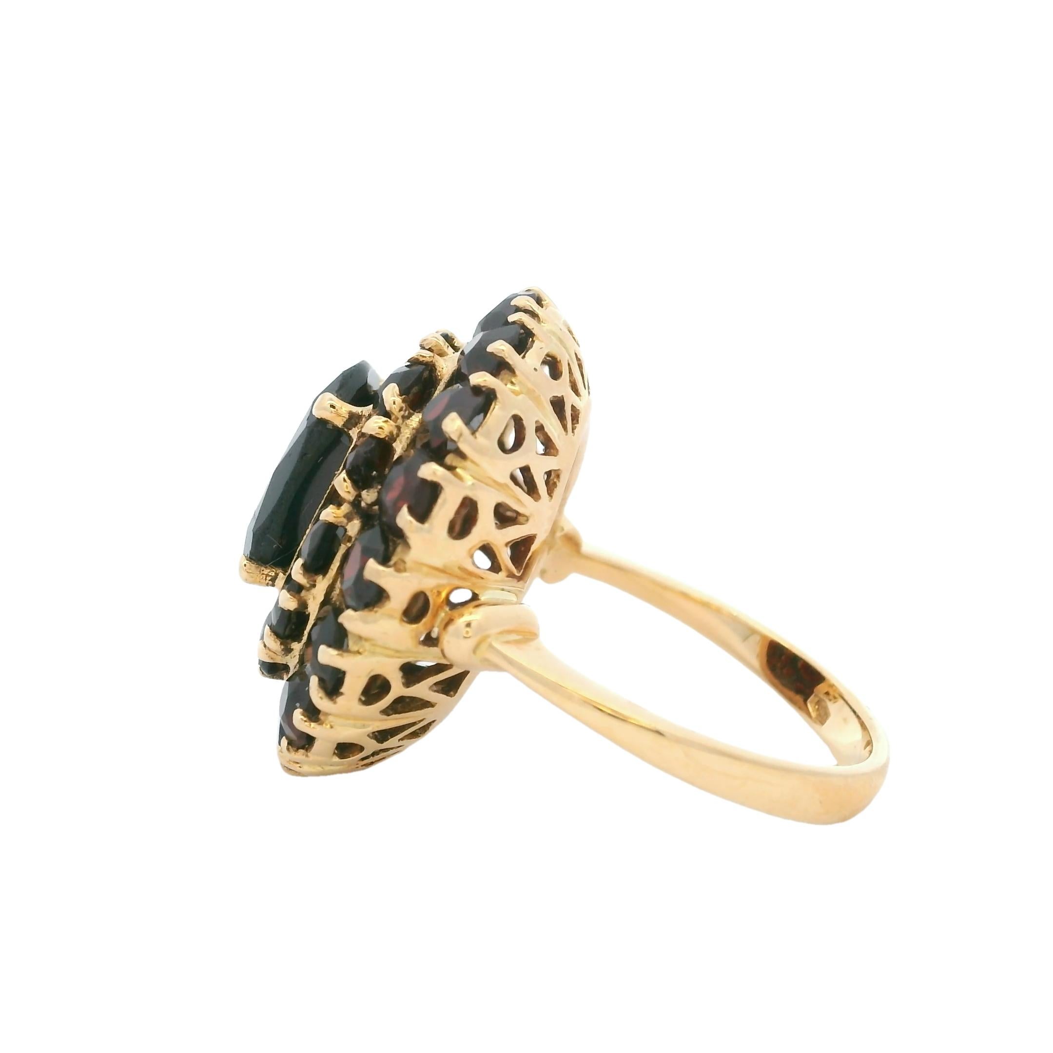 Cette exquise bague à grappes de grenats tchèques vintage est réalisée en or jaune 18 carats et présente un design dramatique à haut dôme composé de grenats rouges ardents d'une valeur totale d'environ 10,00 carats. Le grenat central facetté est