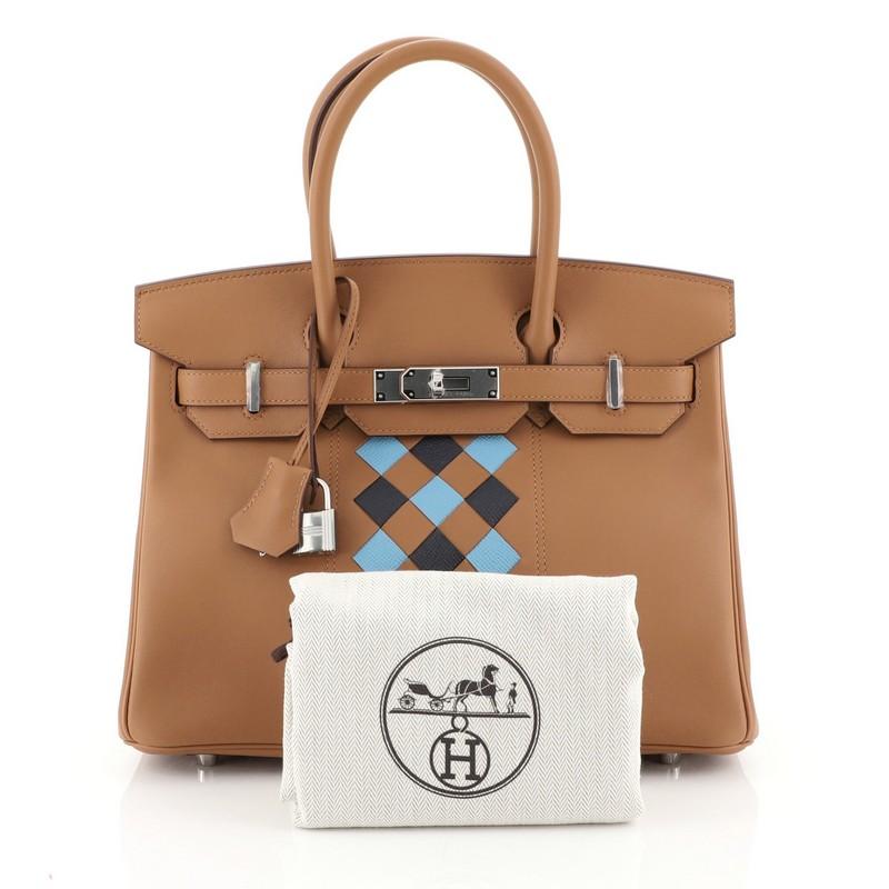 This Hermes Birkin Handbag Tressage Gold Swift and Palladium Hardware 30, crafted in Gold brown Swift, Bleu du Nord blue and Bleu Indigo blue Epsom leather, features dual rolled handles, front flap, and palladium-tone hardware. Its turn-lock closure