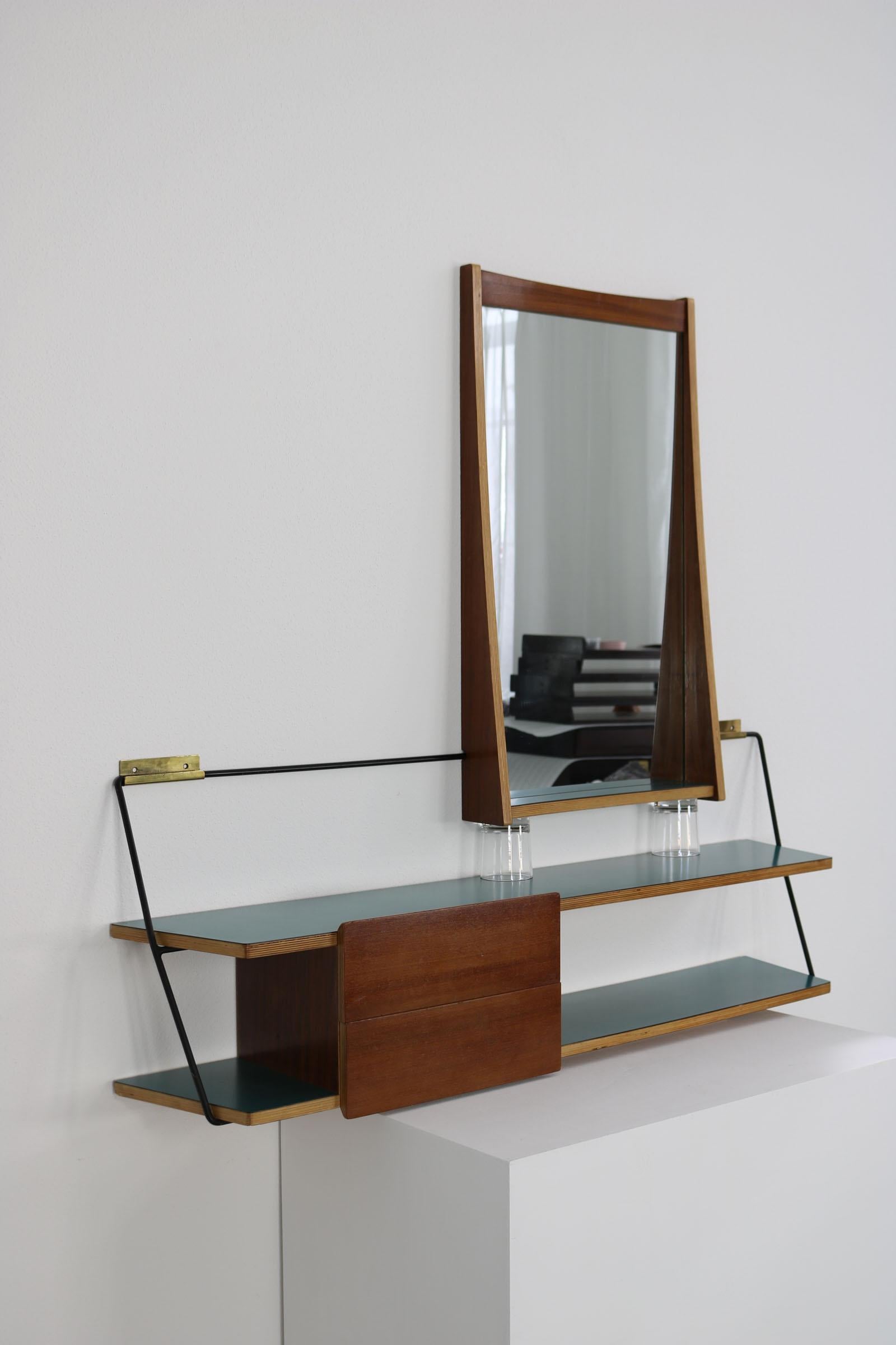 This Italian set, consisting of a mirror and a console, dates from the 1950s and was designed by Eugenia Alberti Reggio. The rectangular mirror is framed by teak. The console is also made of teak, the surfaces were lacquered olive green and the iron