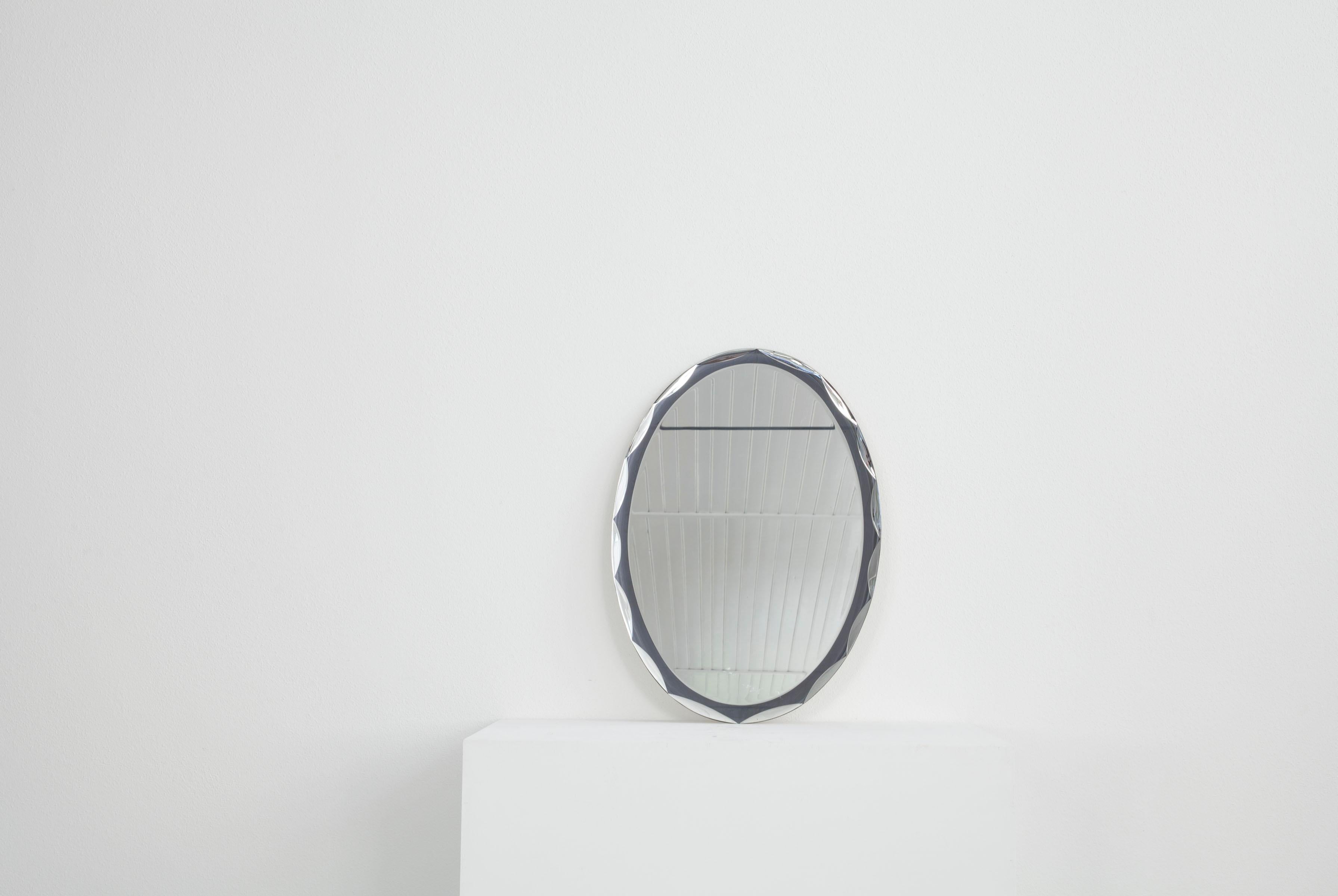 Dieser ovale, italienische Wandspiegel stammt aus den 1960er Jahren. Das Besondere an diesem Spiegel ist der Rahmen, der ebenfalls aus verspiegeltem Glas besteht und in dem sich ein Muster befindet. Der Spiegel ist in gutem Zustand.

.