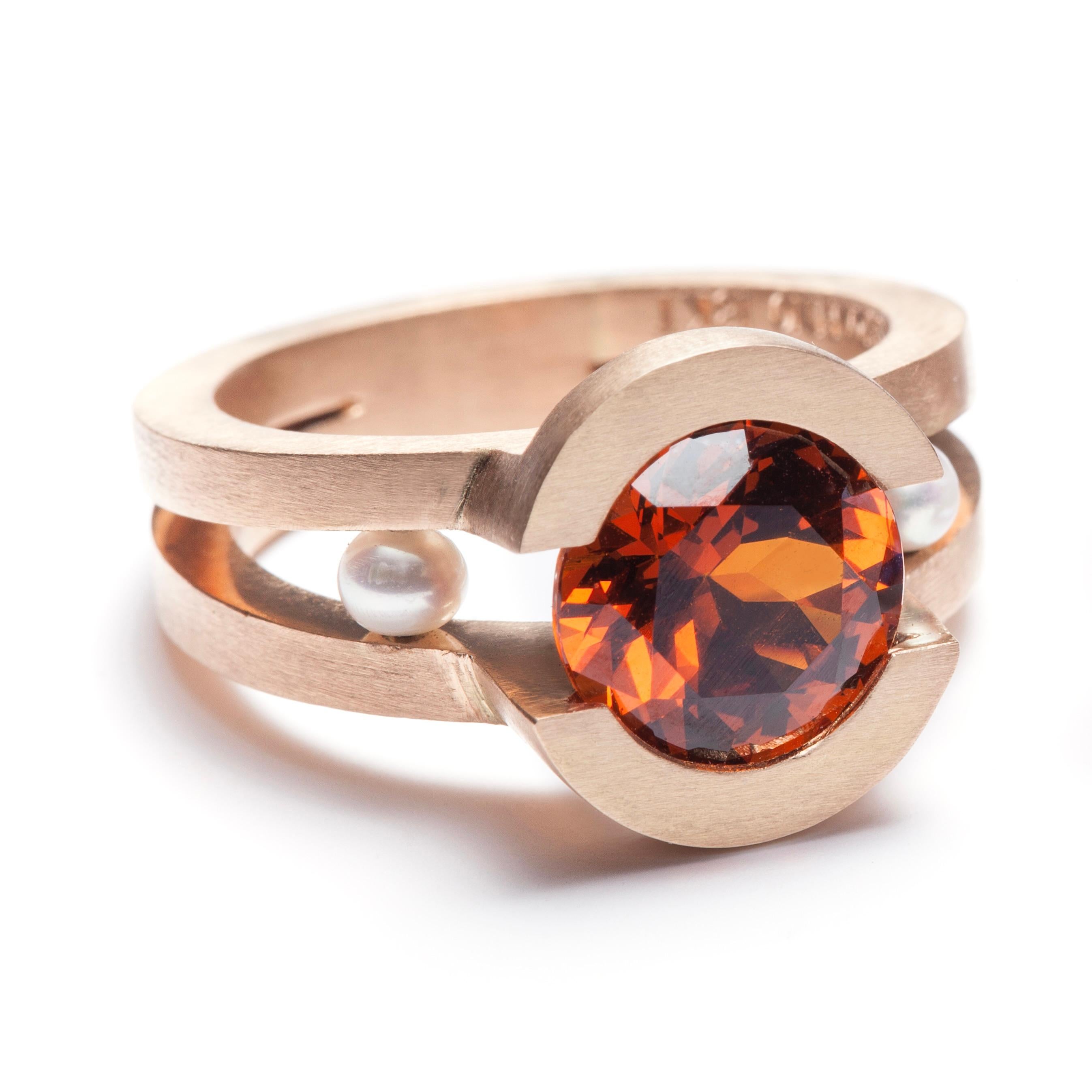 THOLOS Ring in 18kt Pink Gold set with Spessartite Garnet and Pearls by Serafino.

This ring is completely hand forged in 18kt pink gold set with a fiery 3.5 carat spessartite garnet and freshwater pearls. The orangey color of our in-house pink gold