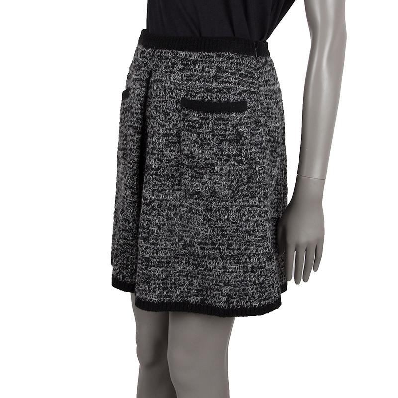 100% authentic Thom Browne knit A-line skirt in black and grey wool (70%), cashmere (100%), mohair (10%), and nylon (10%). With two front patch pockets, box pleat on the front, and two pleated darts on the back. Closes with invisible side zipper.
