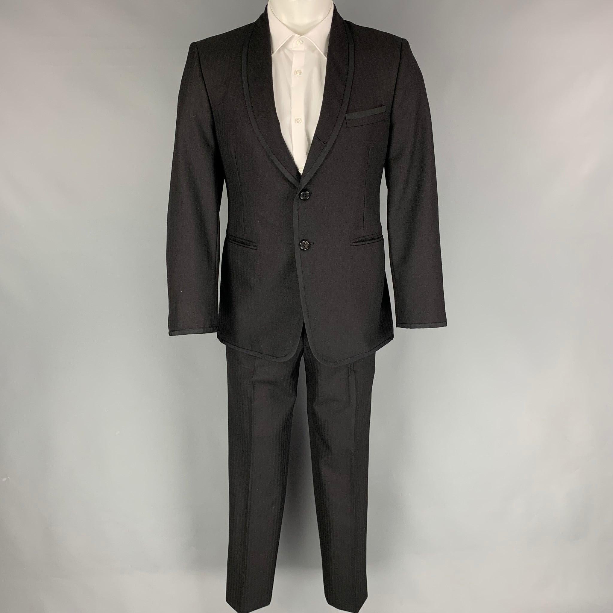 THOM BROWNE for NEIMAN MARCUS tuxedo
suit comes in a black on black herringbone material with a full liner and includes a single breasted, three button sport coat with a shawl lapel and matching pleated front trousers. Handmade in USA.Excellent