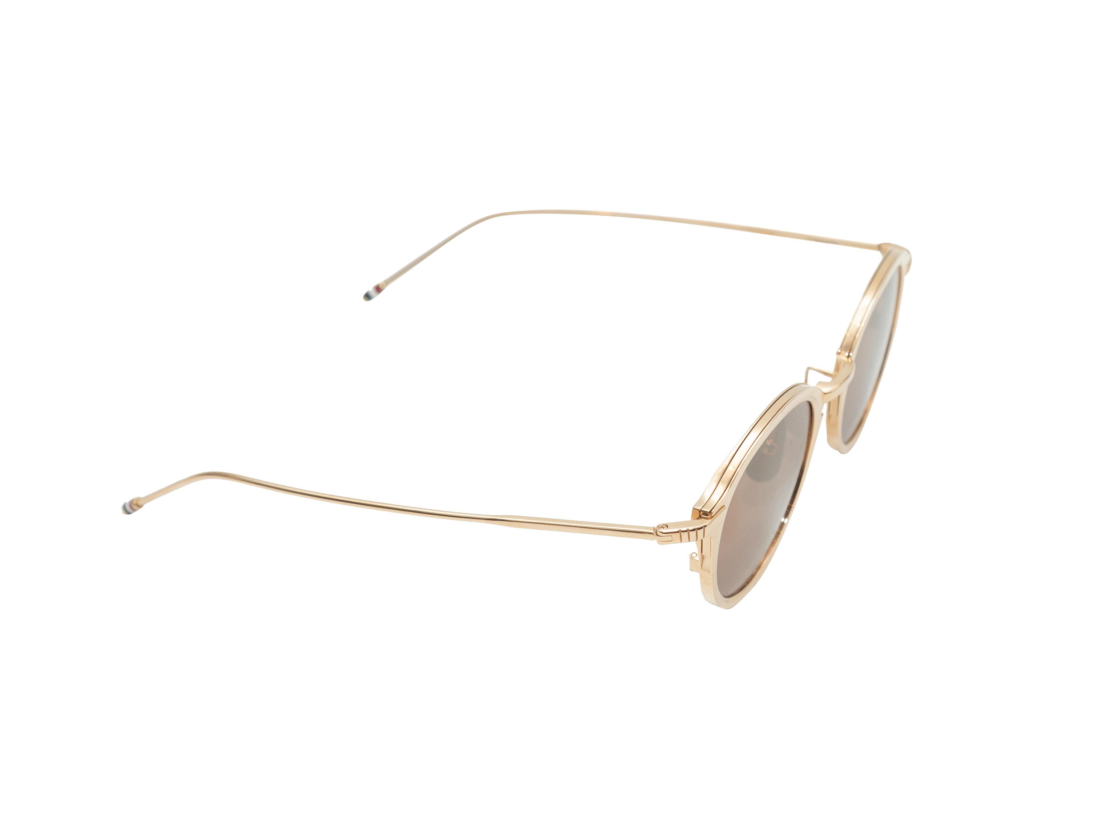Product details: Gold mirrored round sunglasses by Thom Browne. 1.8