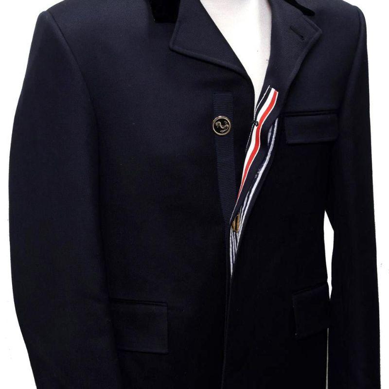Thom Browne Navy Blue XS Classic Chesterfield FW18 Cavalry Twill Men's Overcoat

This classic Thom Browne wool peacoat is a timeless investment piece for you wardrobe. Crafted of a pure wool in a navy with a velvet collar and signature red blue
