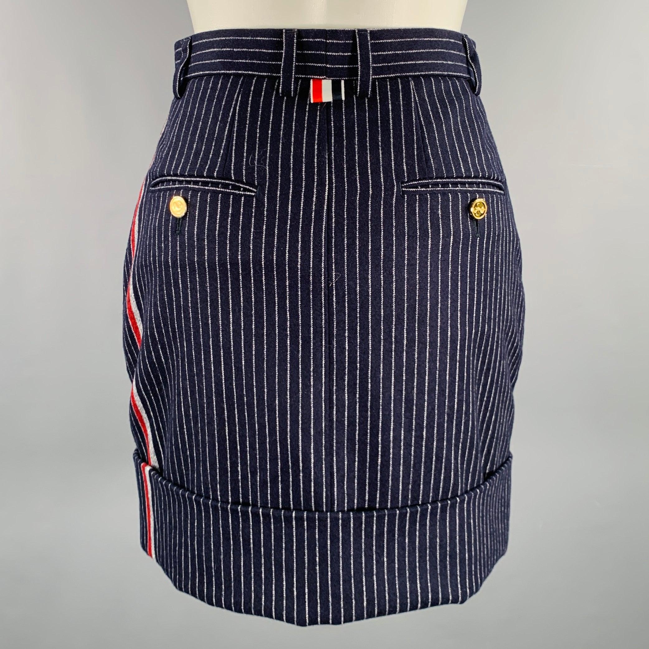 Minifalda THOM BROWNE
en tejido de cachemira de lana azul marino y blanco, con estampado de rayas, diseño de puños y cierre de bragueta con cremallera. Fabricado en Italia.Excelente estado de conservación. 

Marcado:   IT 36 

Medidas: 
  Cintura: