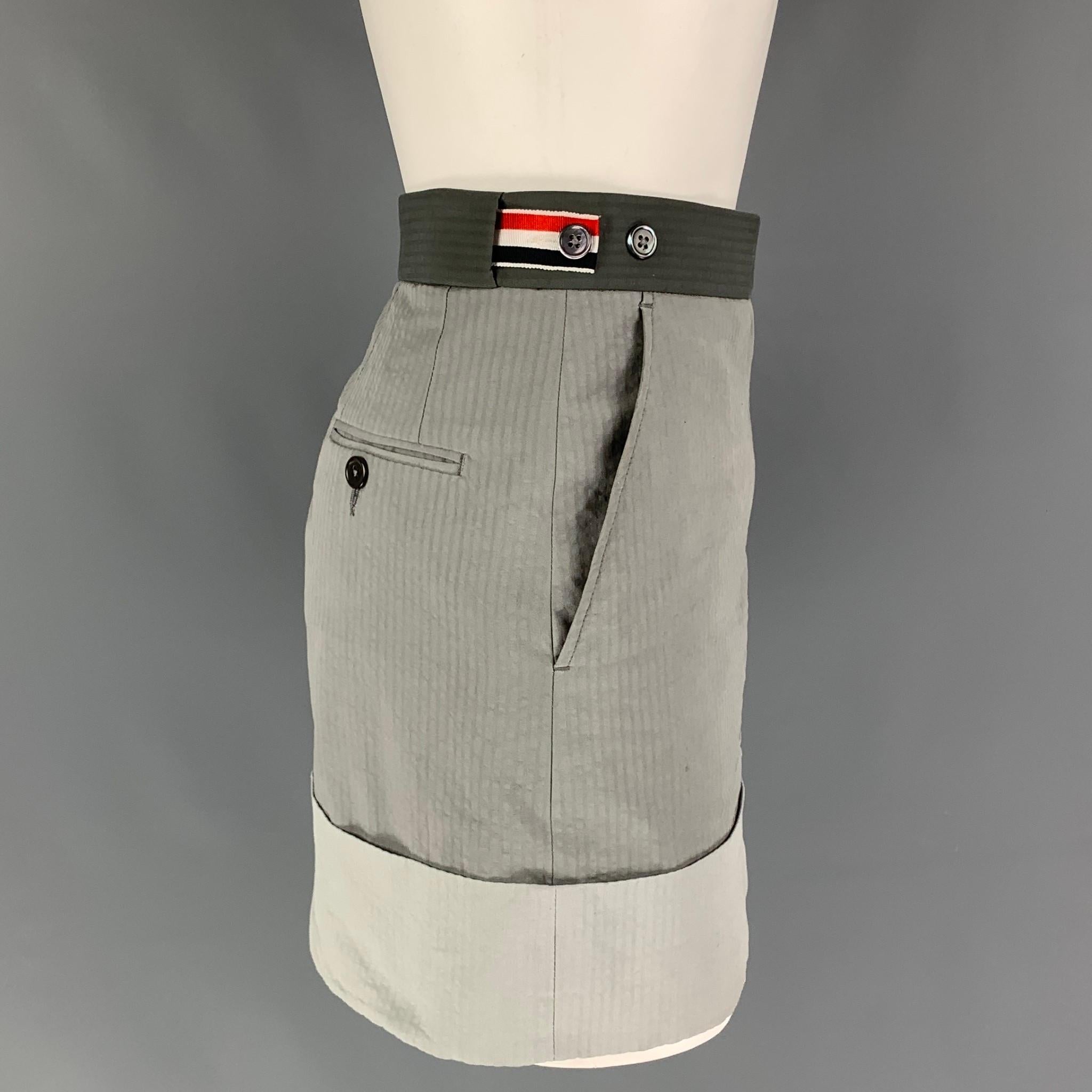 THOM BROWNE skirt comes in a grey & light grey color block with a stripe interior featuring a mini style, cuffed hem, side stripe tabs, front tab, slit pockets, and a zip fly closure. Made in Italy.

Very Good Pre-Owned Condition.
Marked: