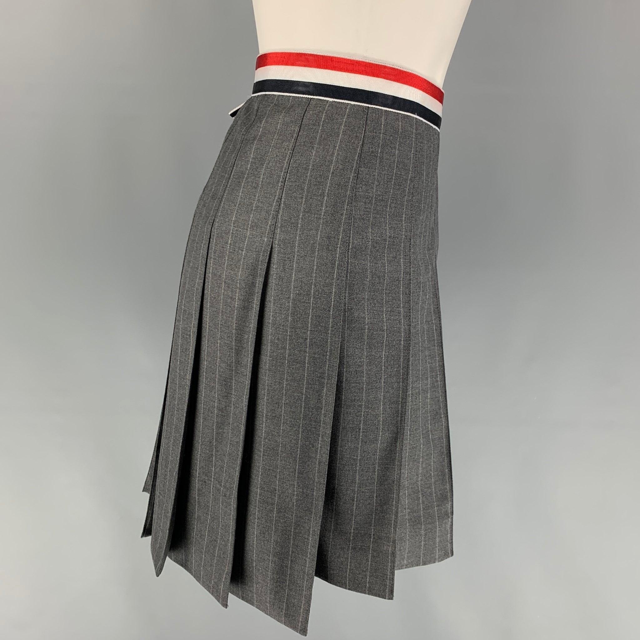 THOM BROWNE skirt comes in a gray & charcoal stripe wool featuring a pleated style, signature stripe trim, and a side zipper closure. Matching jacket sold separately. Made in Italy.
Very Good
Pre-Owned Condition. 

Marked:   36 

Measurements: 
 