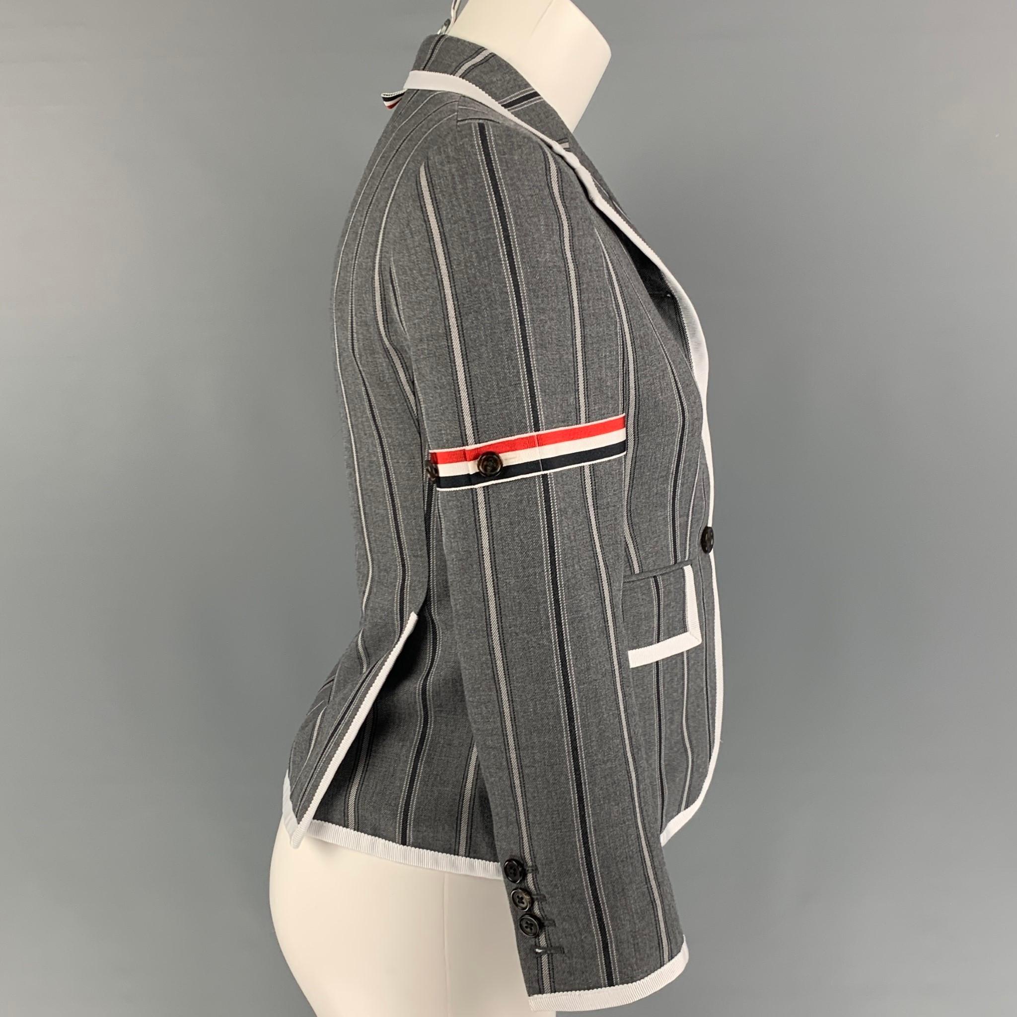 THOM BROWNE jacket comes in a grey & charcoal stripe wool featuring a notch lapel, signature stripe trim, front flap pockets, double back vent, and a three button closure. Matching skirt sold separate. Made in Italy. 

Excellent Pre-Owned