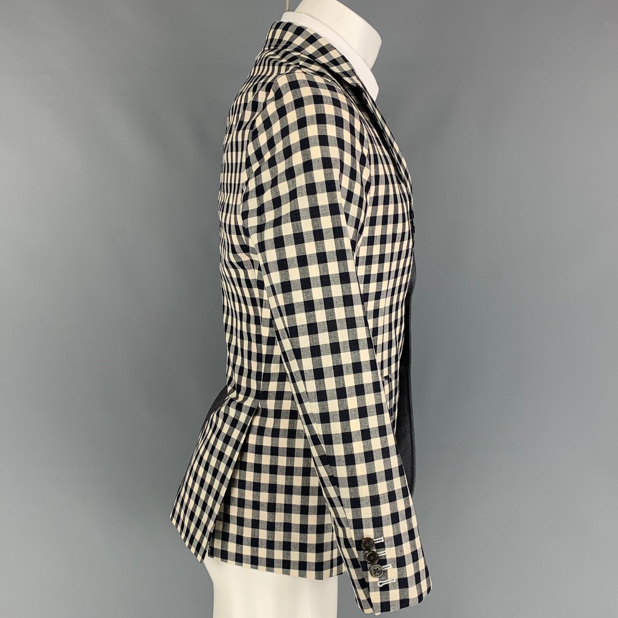 THOM BROWNE sport coat comes in a navy & red wool blend with a half liner featuring a half checkered design. notch lapel, flap pockets, double back vent, and a three button closure. Made in Japan.
Very Good Pre-Owned Condition. Faint mark at arm. 