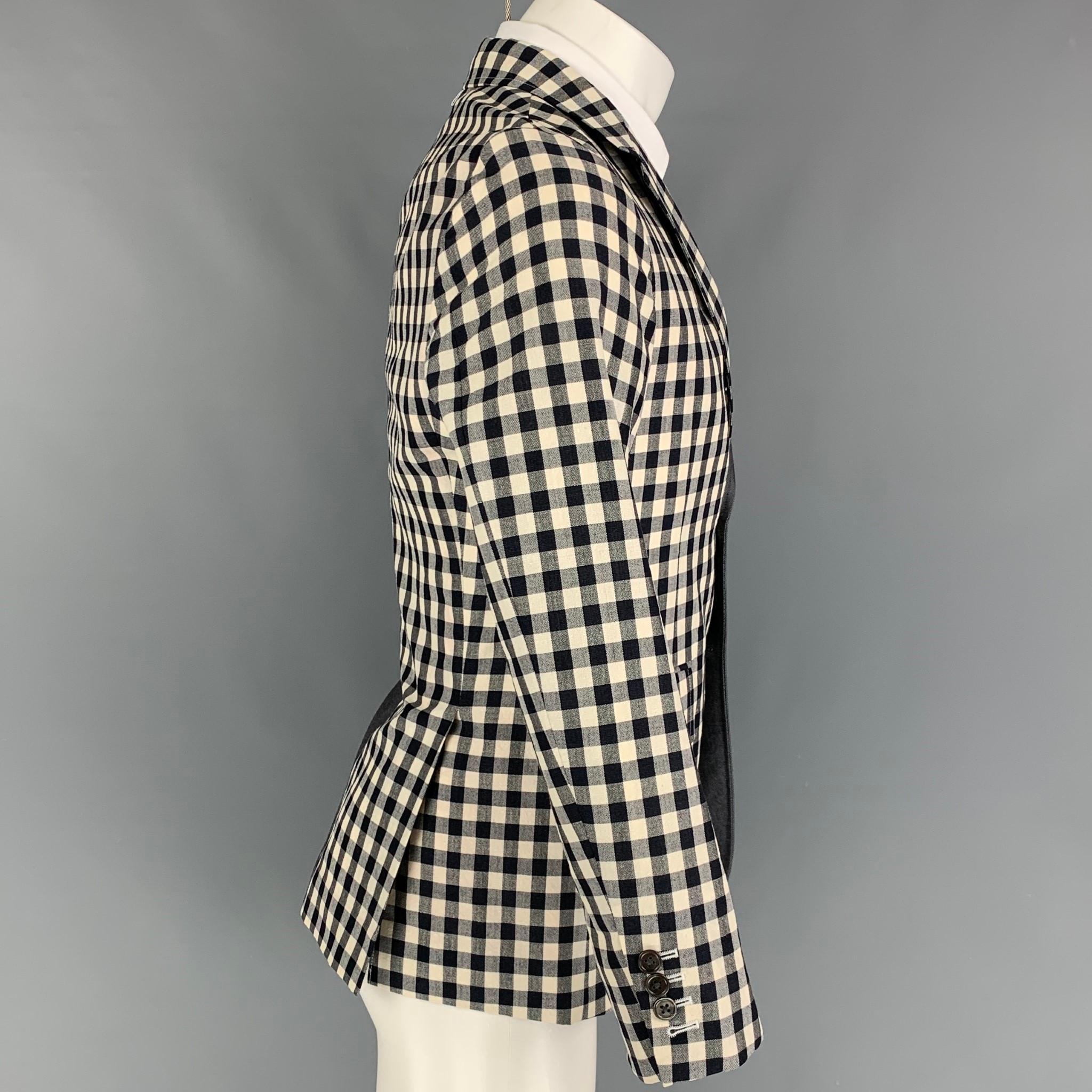 THOM BROWNE sport coat comes in a navy & red wool blend with a half liner featuring a half checkered design. notch lapel, flap pockets, double back vent, and a three button closure. Made in Japan. 

Very Good Pre-Owned Condition. Faint mark at