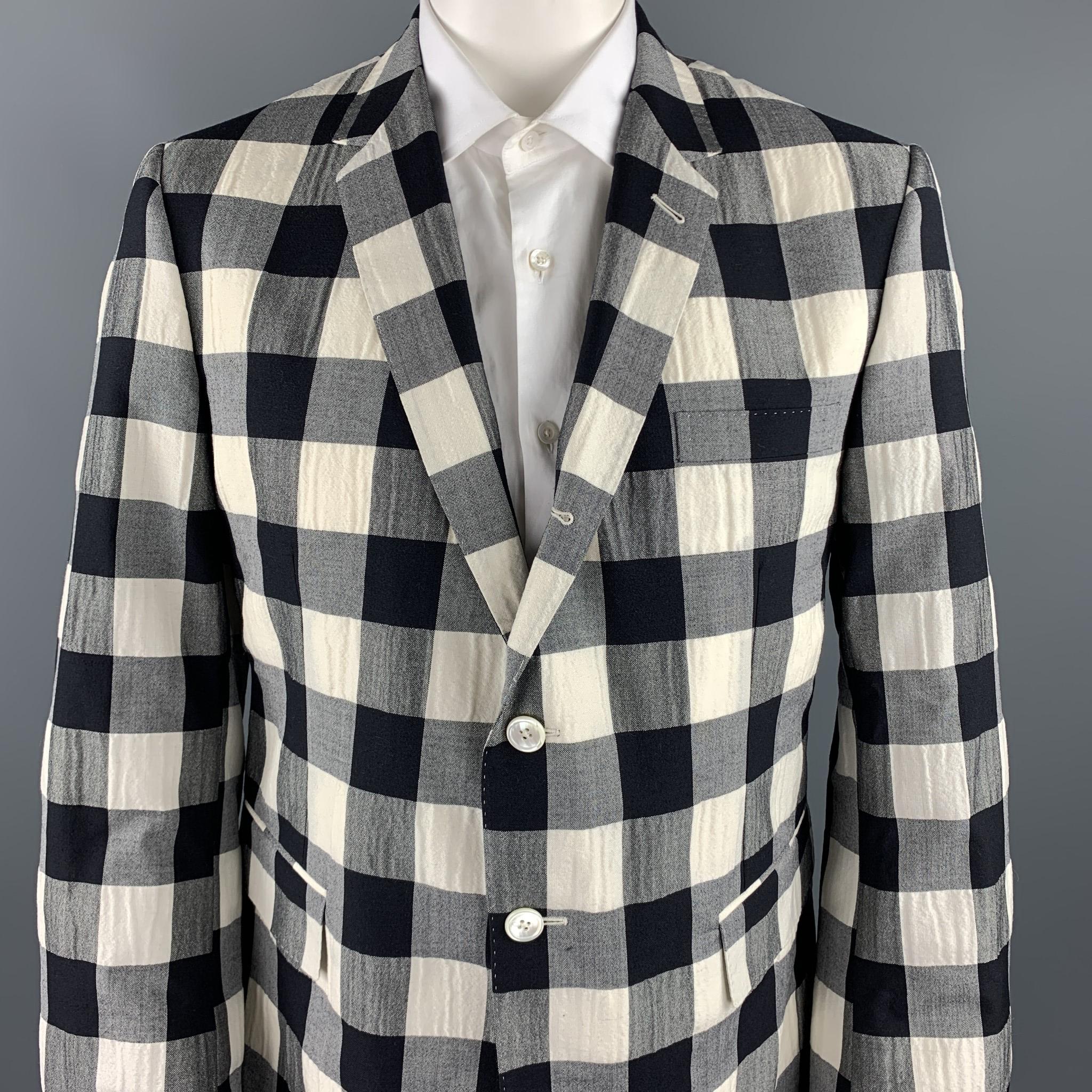 THOM BROWNE sport coat comes in a black & beige checkered wool blend with a full striped liner featuring a notch lapel, flap pockets, and a three button closure. Made in Italy.

Excellent Pre-Owned Condition.
Marked: 50 R 

Measurements:

Shoulder: