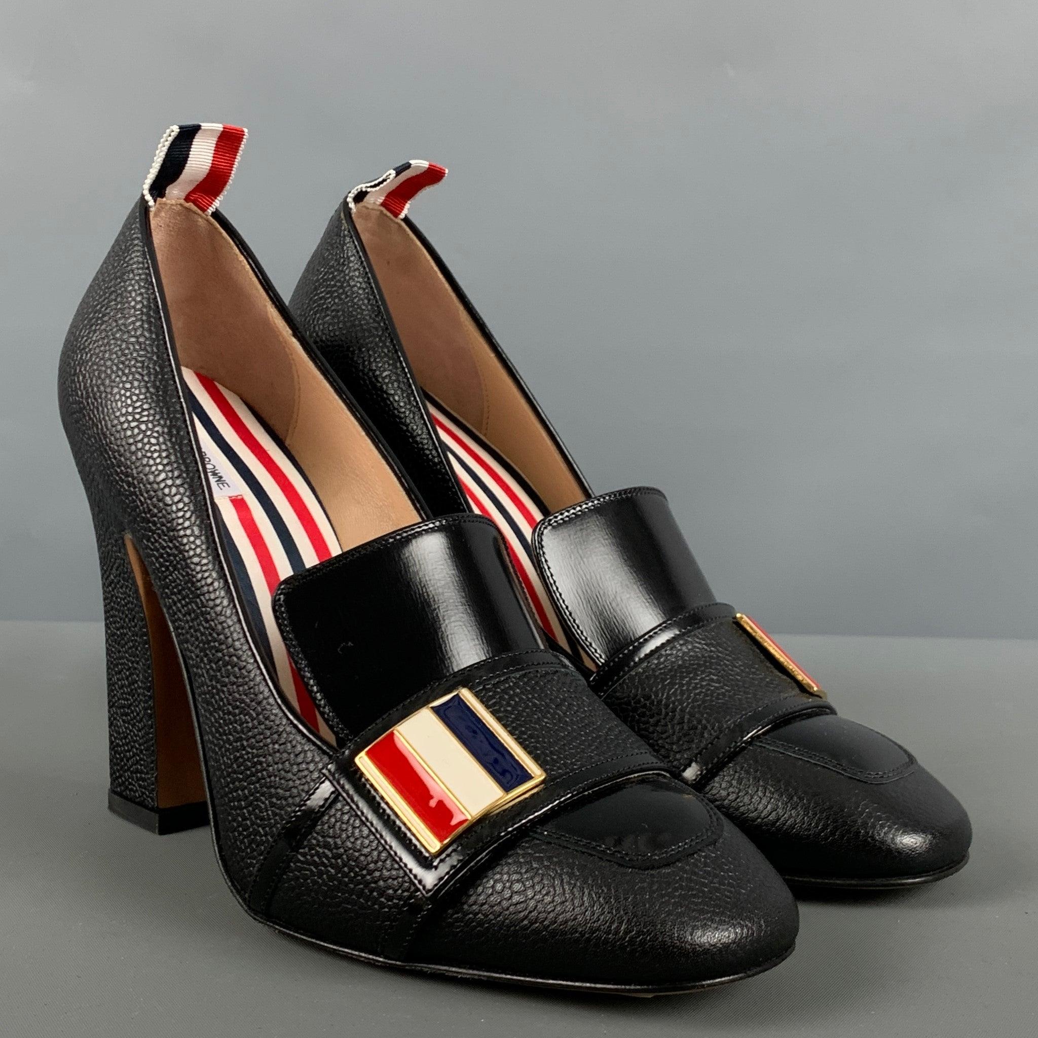 THOM BROWNE
 pumps comes in a black pebble leather featuring a red, white and blue hardware detail, and a chunky heel. Made in Italy. Excellent Pre-Owned Condition. 

Marked:   38 

Measurements: 
  Heel: 4.5 inches  
  
  
 
Reference: