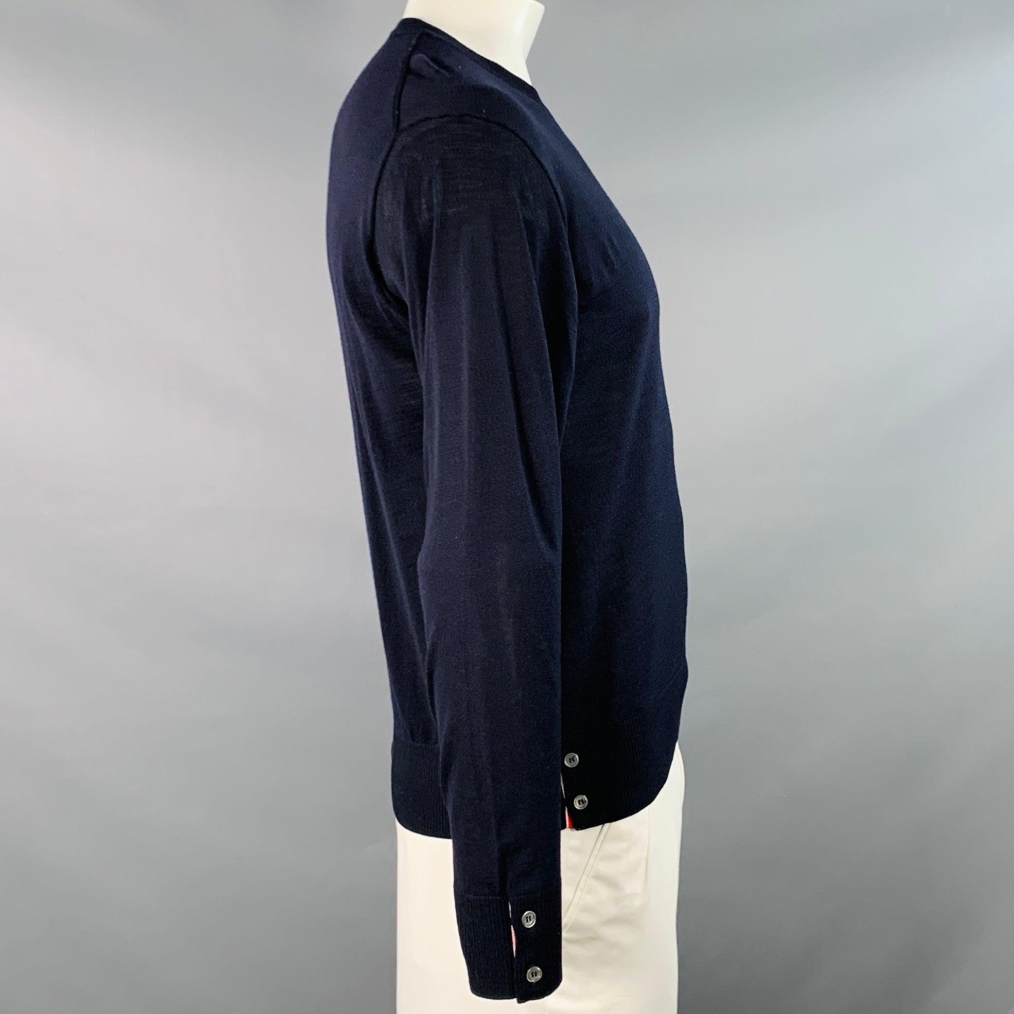 Pull THOM BROWNE
en jersey de laine mérinos bleu marine, avec manches à quatre bandes blanches, bordures rouges, blanches et bleues contrastées aux poignets et à l'ourlet, et col ras du cou. Fabriqué en Italie. Très bon état. Léger boulochage.