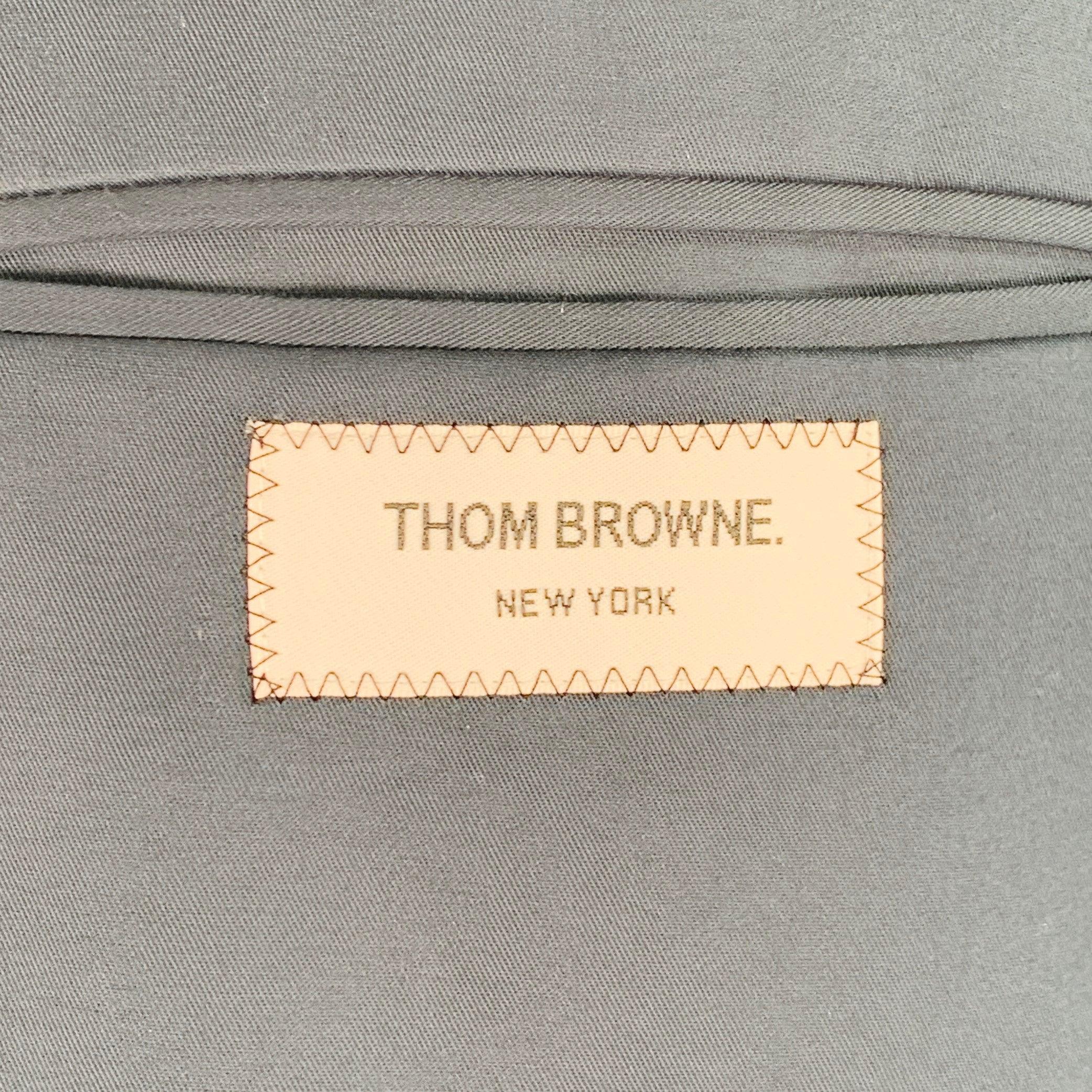 THOM BROWNE shirt jacket
in a navy woven twill (feels like cotton) featuring three pockets (one with flap and button closure), gold tone metal hardware, and snap closure. Made in Japan.Excellent Pre-Owned Condition. Tags removed. 

Marked:   2