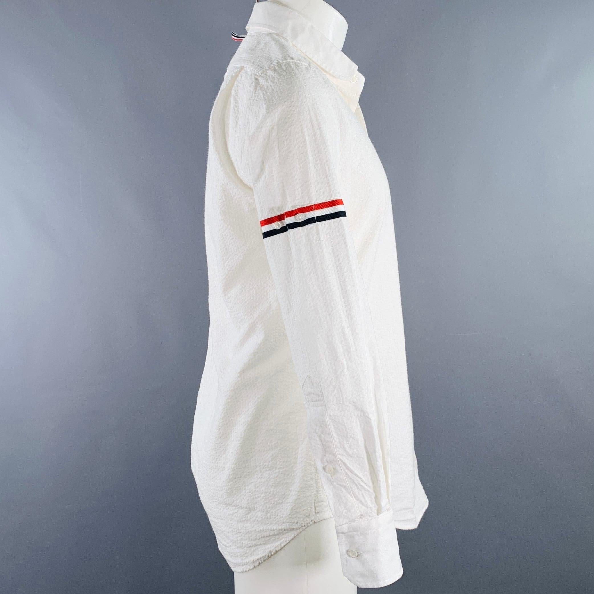 THOM BROWNE long sleeve shirt
in a white woven seersucker fabric (feels like cotton) featuring red and navy stripe sleeve ribbon details, one pocket, and button closure. Made in Italy.Excellent Pre-Owned Condition. 

Marked:   1 

Measurements: 

