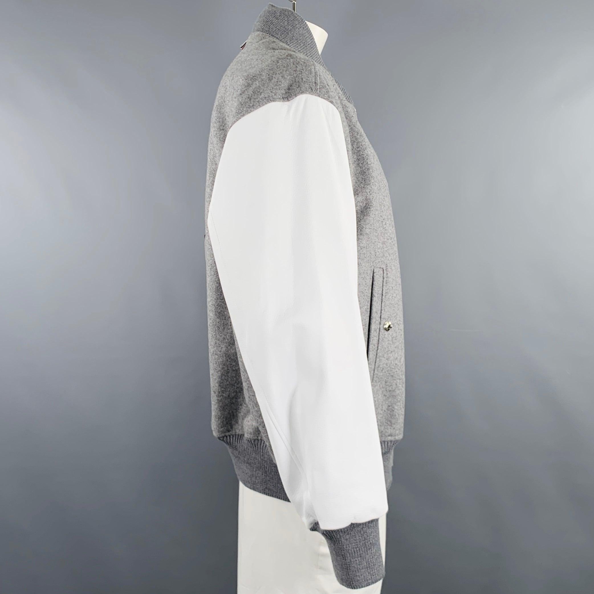 THOM BROWNE jacket
in a grey wool and white lambskin leather featuring a varsity style, signature stripe sleeve detail, and zip up closure. Made in Italy.Excellent Pre-Owned Condition. 

Marked:   4 

Measurements: 
 
Shoulder: 22 inches Chest: 54