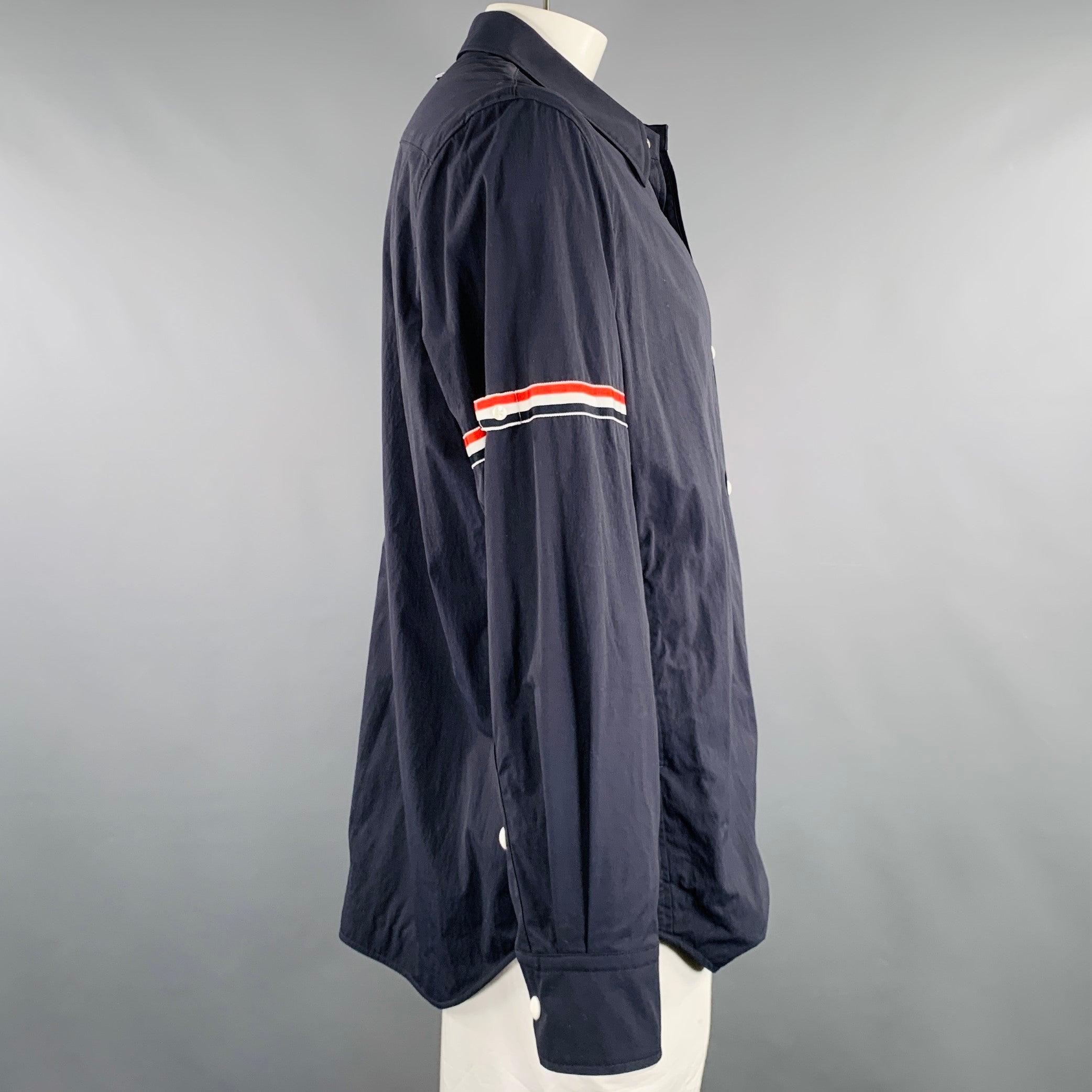 THOM BROWNE jacket
in a navy nylon fabric featuring a shirt jacket style, one pocket, adjustable sleeves, and snap closure. Made in Japan.Excellent Pre-Owned Condition. 

Marked:   4 

Measurements: 
 
Shoulder: 20 inches Chest: 46 inches Sleeve: