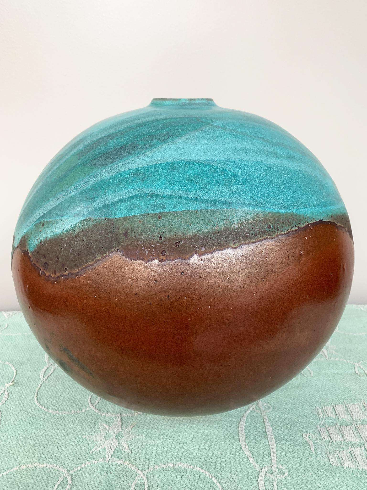 From Thom Lussier's Oxidized Copper Collection - a series of ceramic vessels that stand out for their brilliant palette and rich textures. This vessel is spherical in form with a lipped opening.

White stoneware with metallic