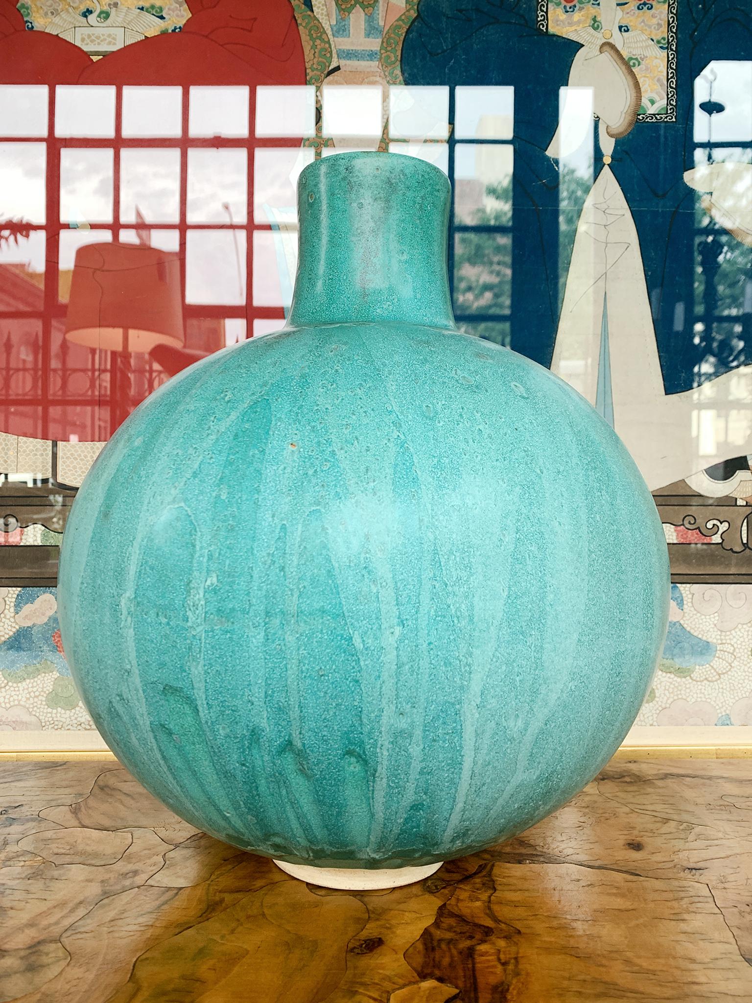 From Thom Lussier's Oxidized Copper Collection - a series of ceramic vessels that stand out for their brilliant palette and rich textures. This vessel is spherical in form with a long neck.

White stoneware with Cone 6 glaze.

Dimensions:
13