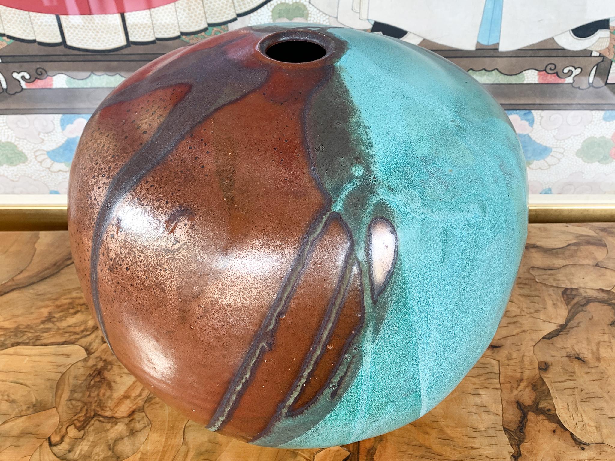 Dalla collezione di rame ossidato di Thom Lussier, una serie di vasi in ceramica che si distinguono per la loro ricca texture e la brillante tavolozza di rame e turchese. Il #7 ha una forma sferica con una piccola apertura.

Gres bianco, smalto a