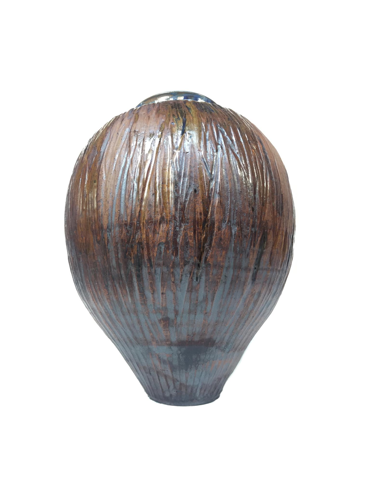 A richly textured ceramic urn from Thom Lussier's 'Fairy' pottery. The artist applies a mixture of different glazing techniques to create various effects in hue and surface. The vase's external surface is reminiscent of wood bark with deep ridges
